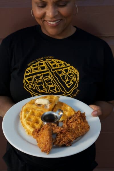 Chef Tanya Holland holding her chicken and waffles. (Jody Horton)