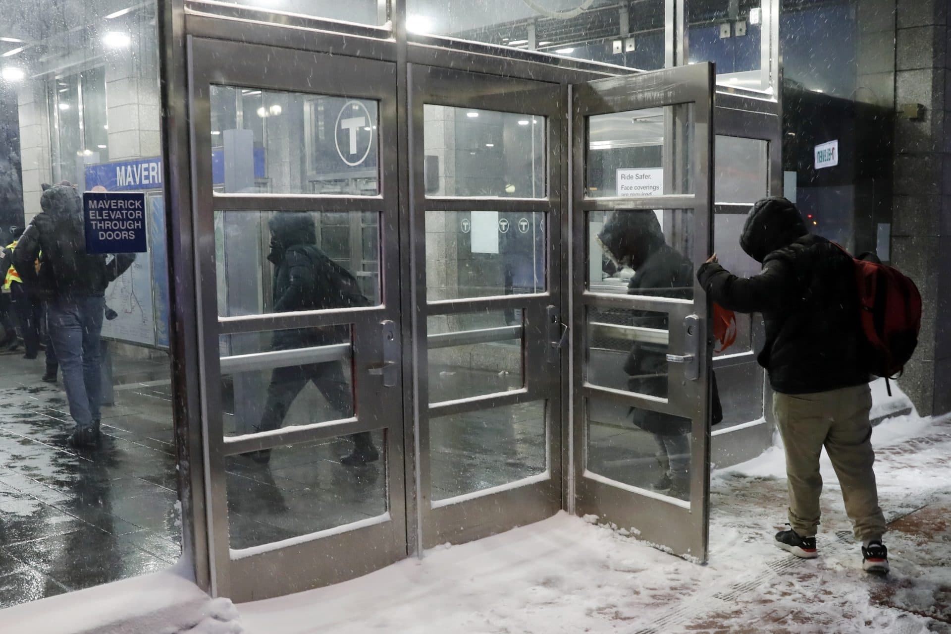 People enter the Maverick T station during Saturday's snowstorm. (Michael Dwyer/AP)