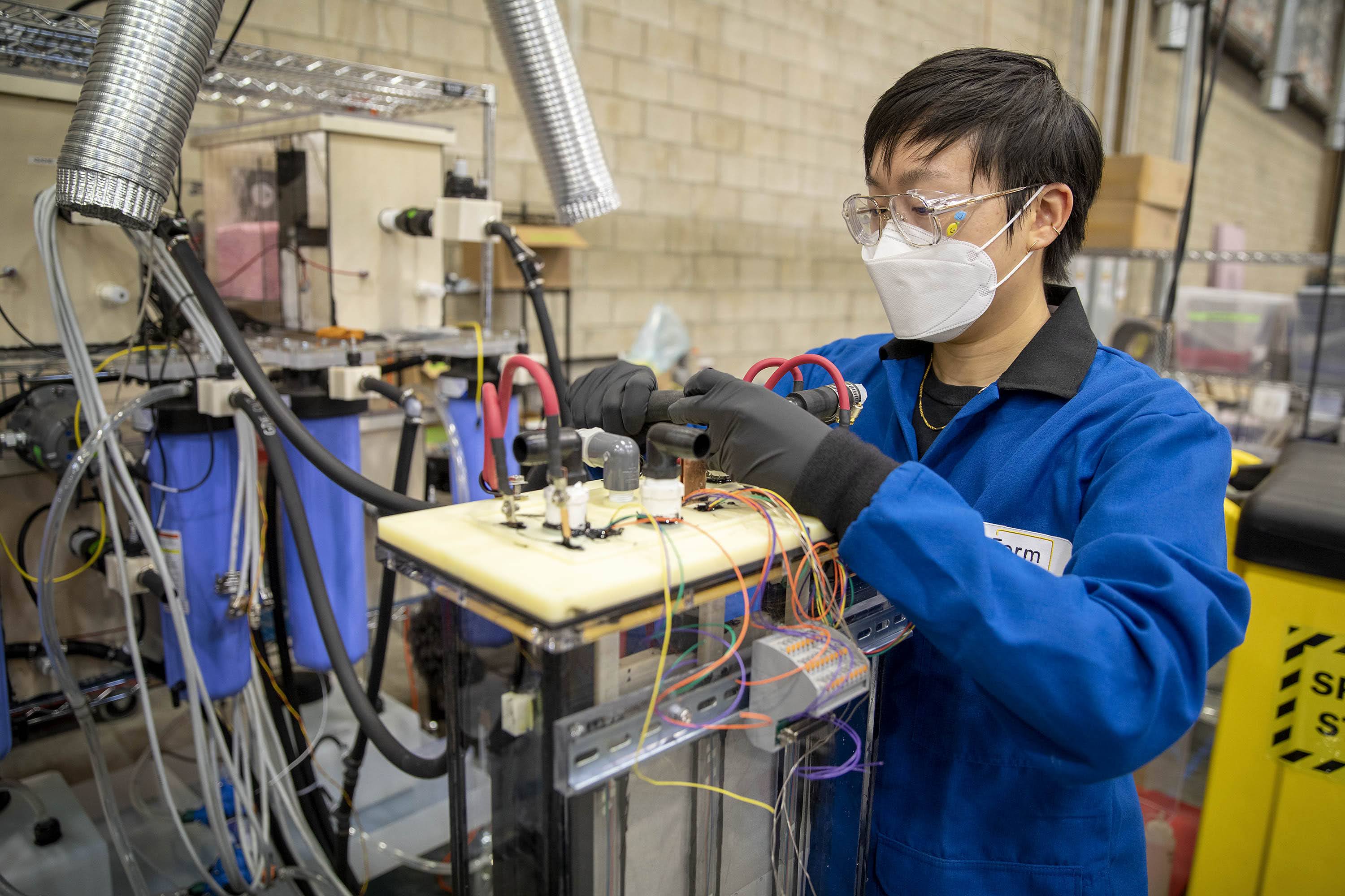 Mechanical engineer Kalina Yang prepares a section of an iron-air battery for testing. (Robin Lubbock/WBUR)