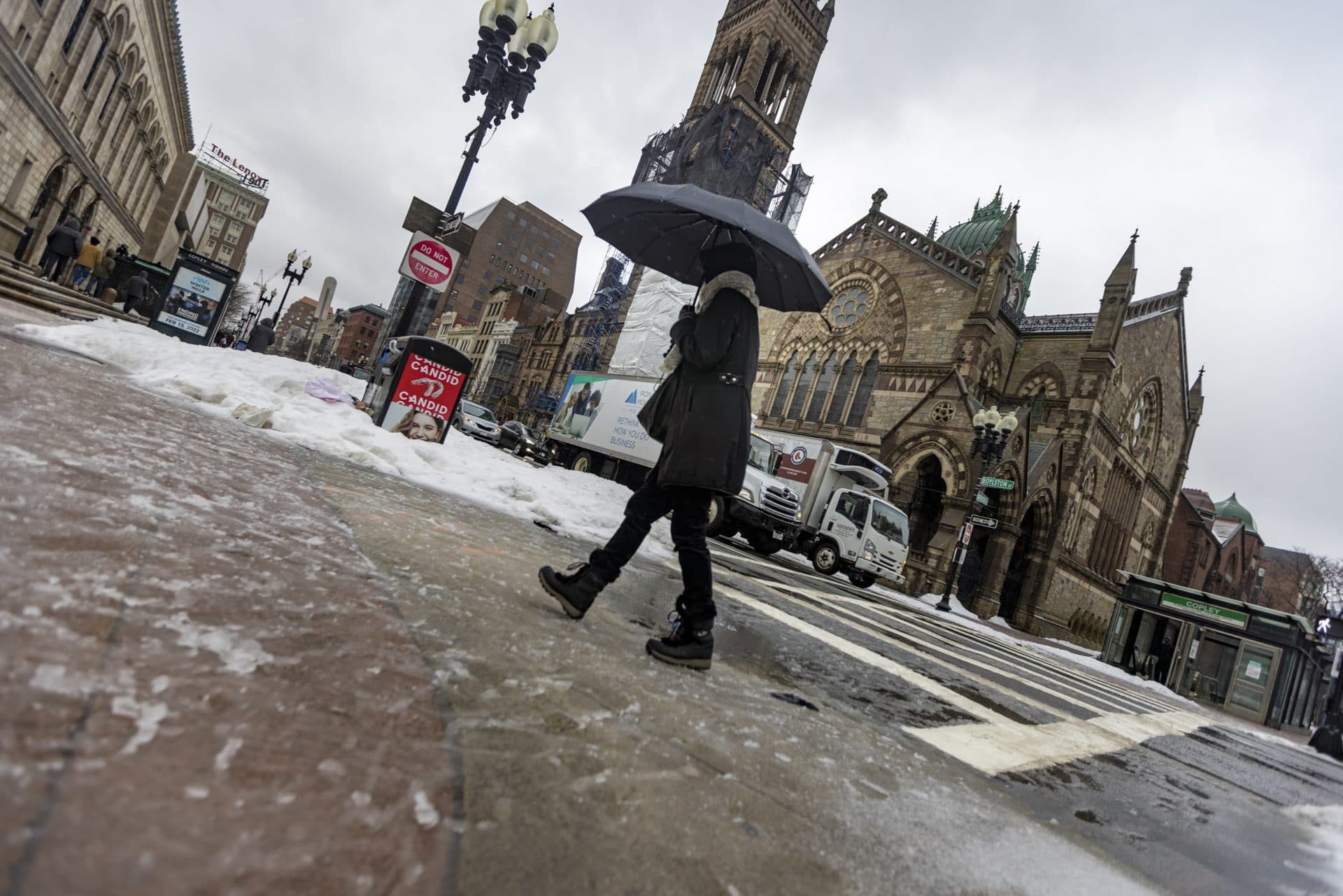 A woman with an umbrella walks through the freezing rain in Copley Square. (Jesse Costa/WBUR)
