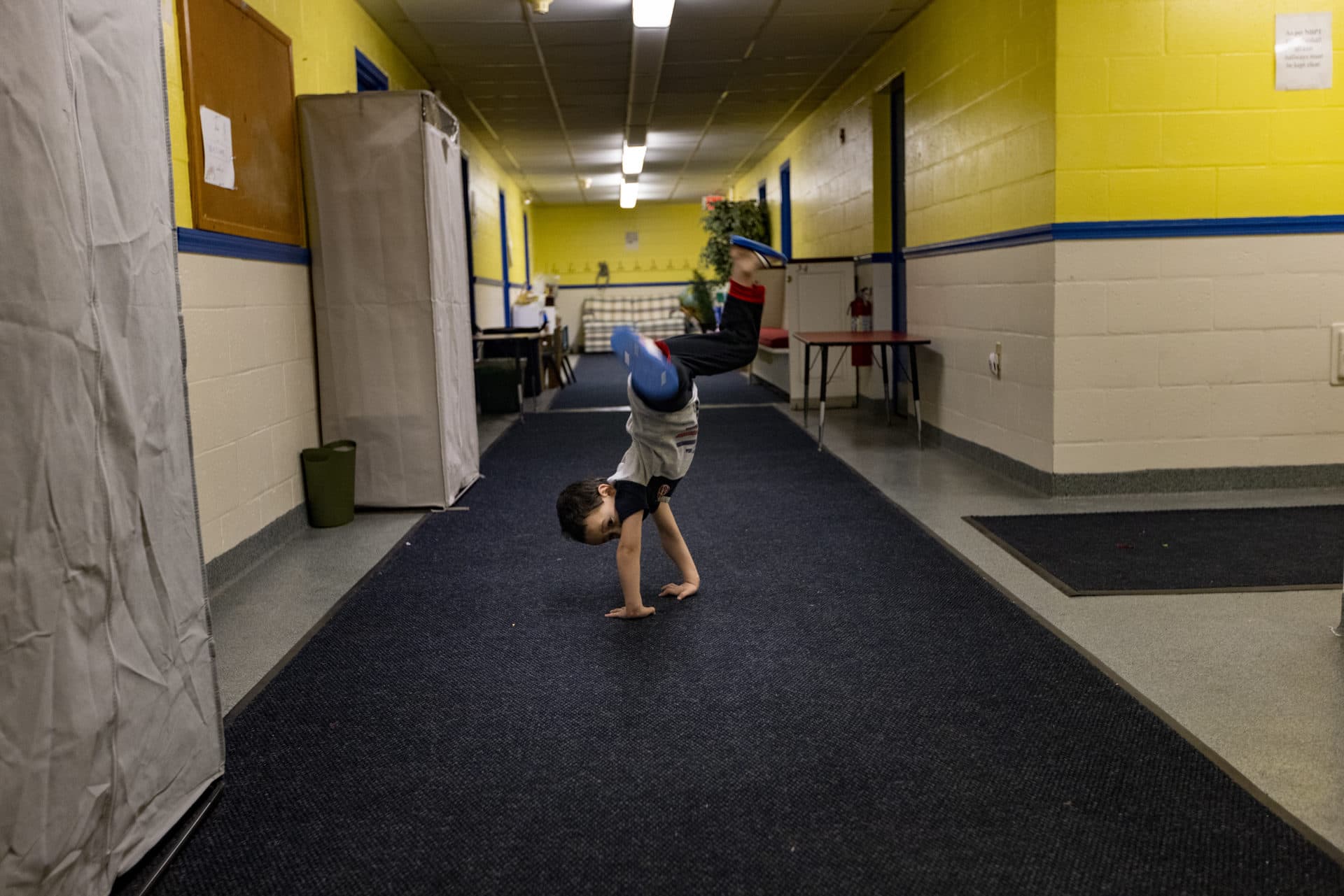 Sanjar, 5, does a cartwheel in the hallway of the basement at St. Paul's Episcopal Church in Newburyport. (Jesse Costa/WBUR)