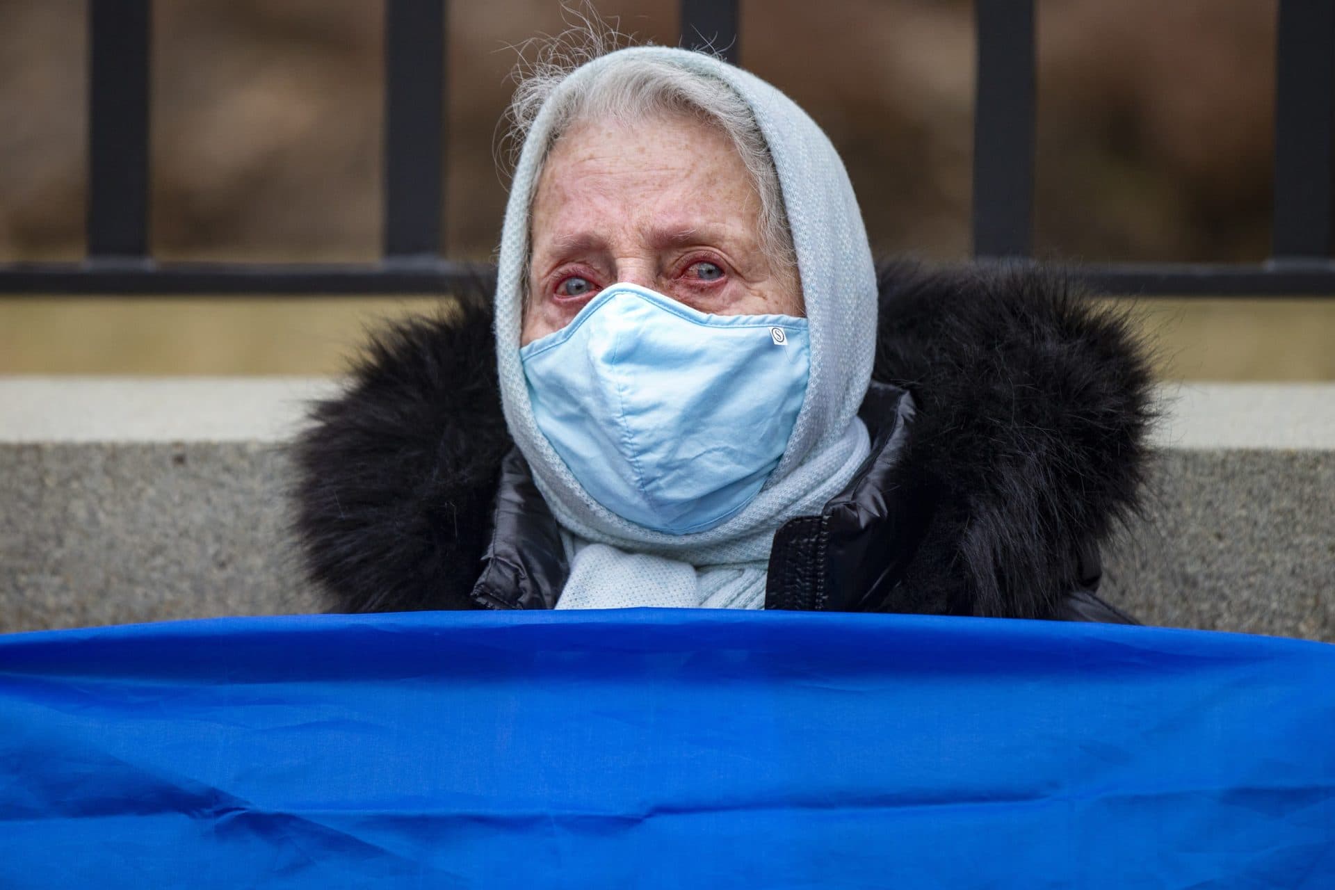 The eyes of Rita Shabisnakova well up with tears during a rally to support Ukraine at the State House. (Jesse Costa/WBUR)