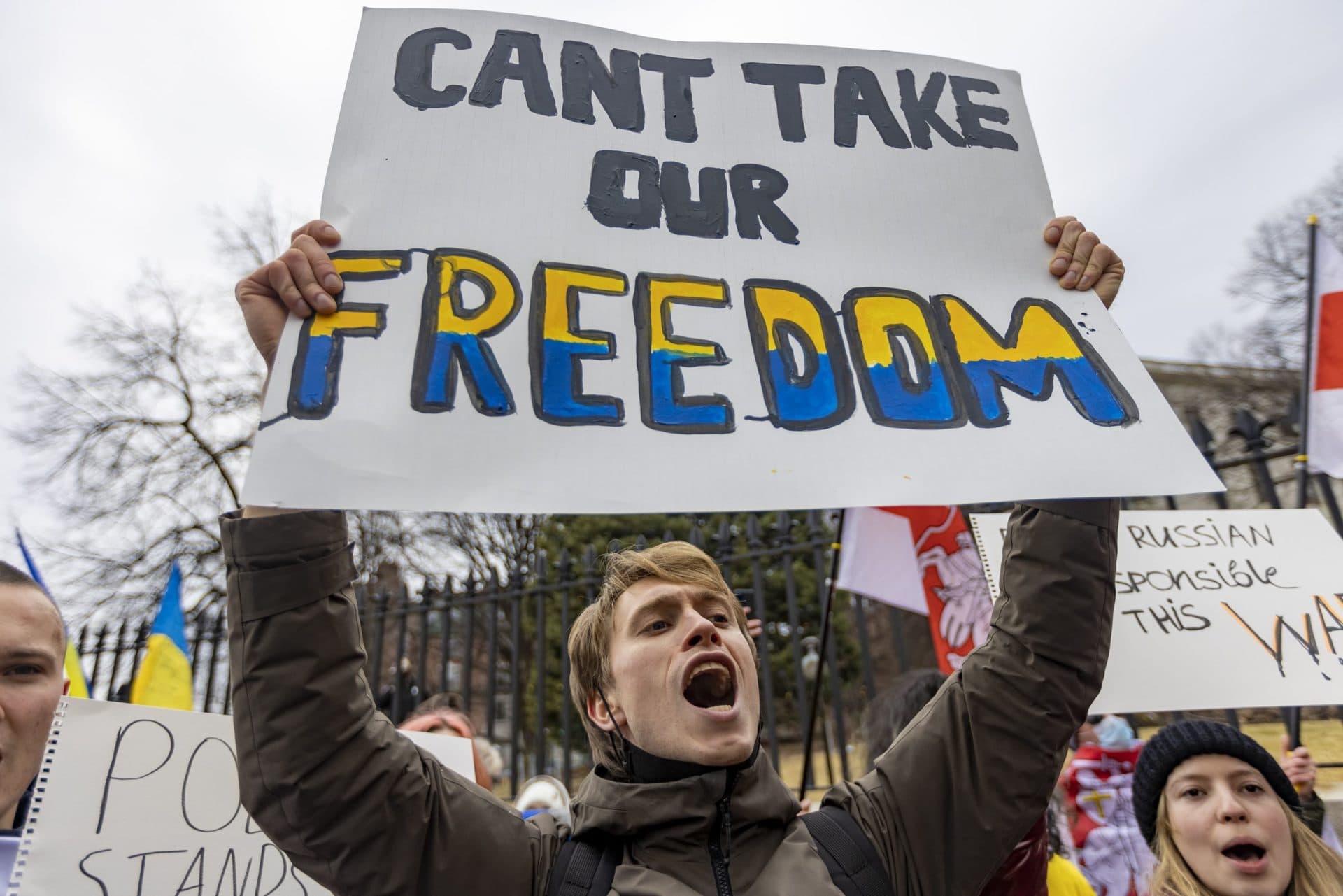 Artem Laptiev, an MIT student from Ukraine, chants and holds a sign during the rally. (Jesse Costa/WBUR)