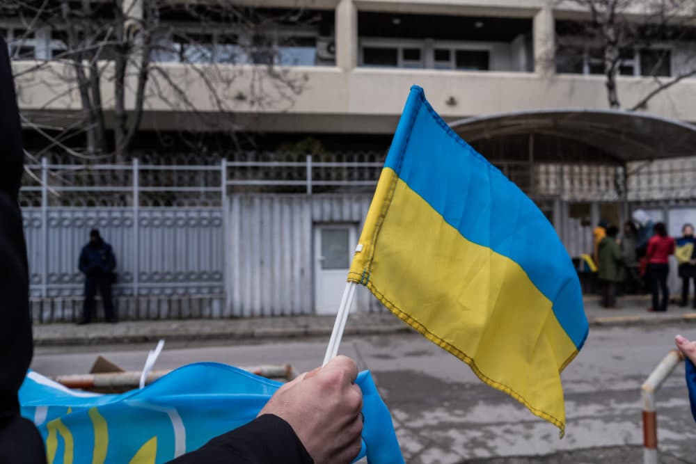 A woman waves an Ukrainian flag during a protest in front the Russian consulate on Feb. 24, 2022 in Varna, Bulgaria. (Hristo Rusev/Getty Images)