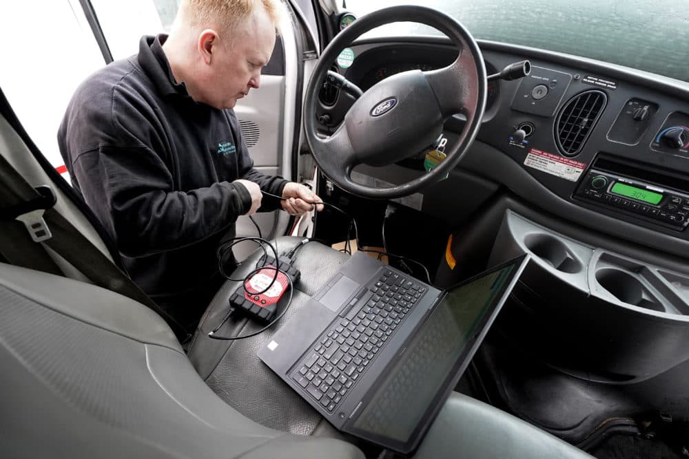 Brian Hohmann, mechanic and owner of Accurate Automotive, in Burlington, Massachusetts, attaches a diagnostics scan tool to a vehicle. (Steven Senne/AP)