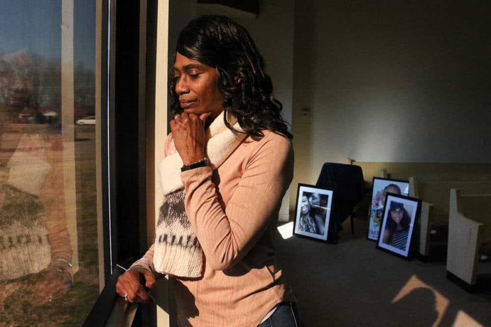 Shirl Baker looks out the window at her church. Behind her are photos of her daughter, DeEbony Groves, who was killed in the Waffle House shooting in 2018. (Paige Pfleger/WPLN)