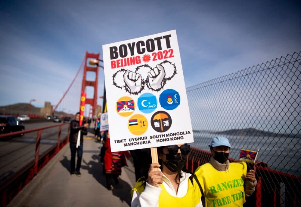 A protester holds up a &quot;Boycott Beijing 2022&quot; sign after marching across the Golden Gate Bridge during a demonstration against the 2022 Beijing winter Olympic Games, in San Francisco, California on Feb. 3, 2022. (Josh Edelson/AFP via Getty Images)