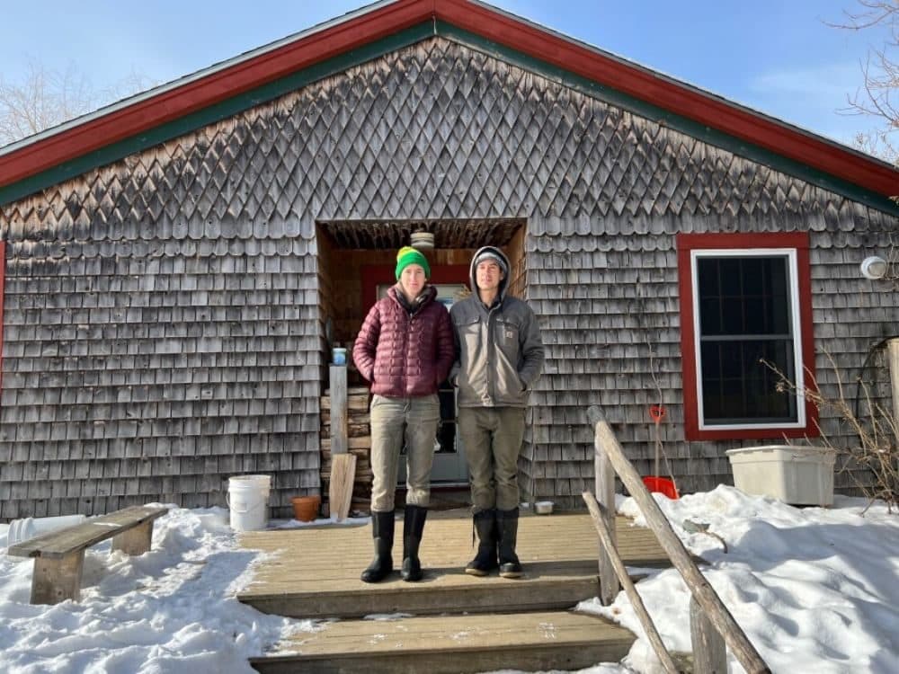Johanna Davis and Adam Nordell stand outside of their house at Songbird Farm, an organic vegetable and grain farm they have operated in Unity since 2014. (Kevin Miller/Maine Public)