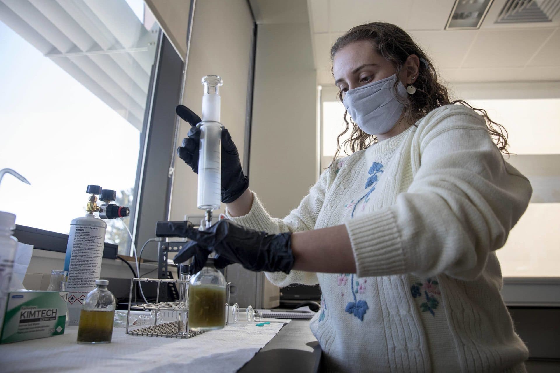 Research technician Gabriella Iacono demonstrates how to remove a gas sample from a test bottle. (Robin Lubbock/WBUR)