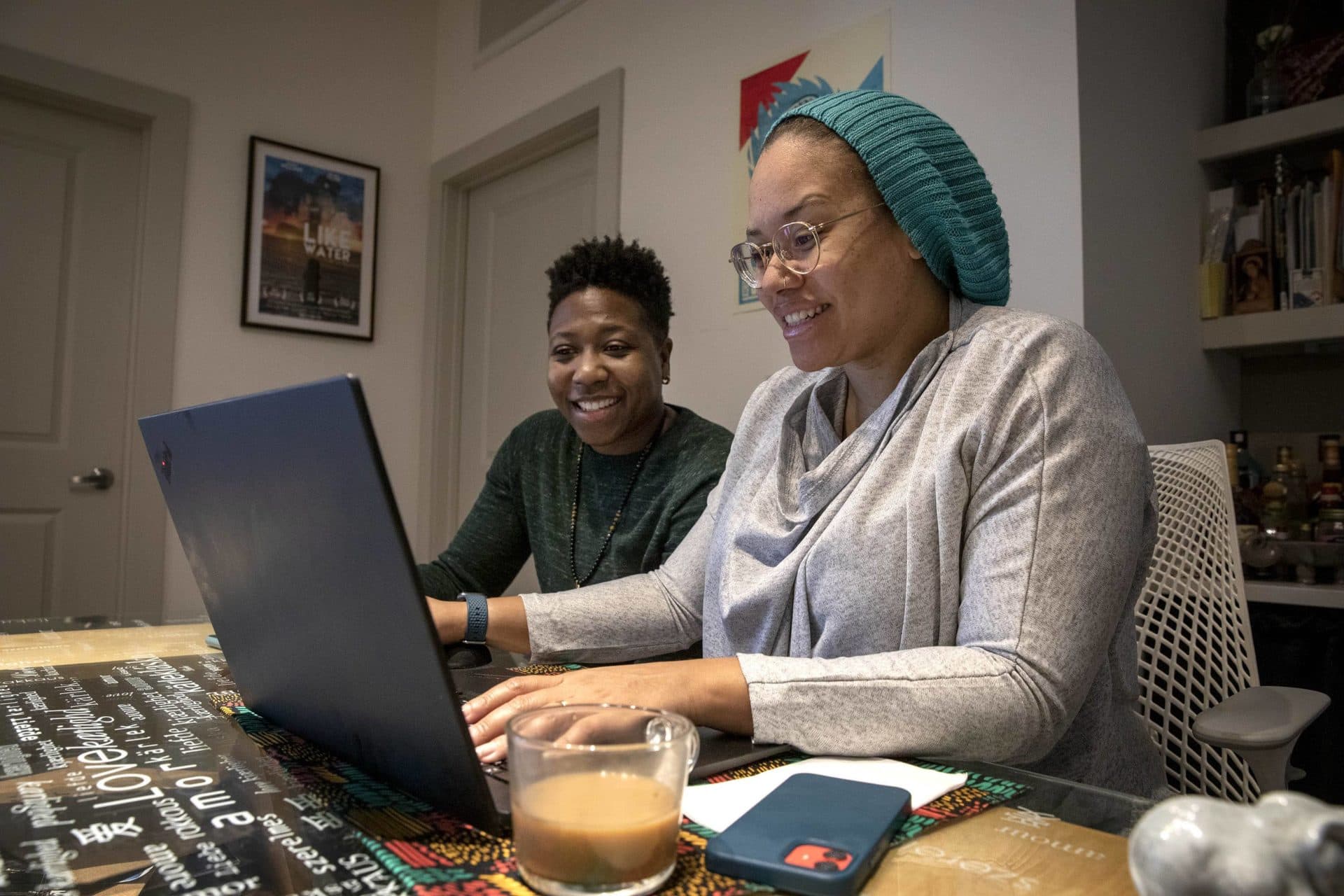 Kellie and Jha D. Amazi search online listings looking for a house in Boston. (Robin Lubbock/WBUR)