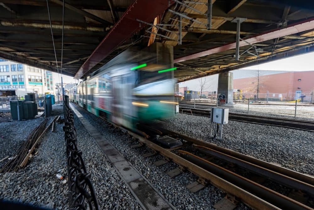An MBTA Green Line train rides on the tracks beneath McGrath Highway in Somerville during testing runs of the Green Line Extension. (Jesse Costa/WBUR)