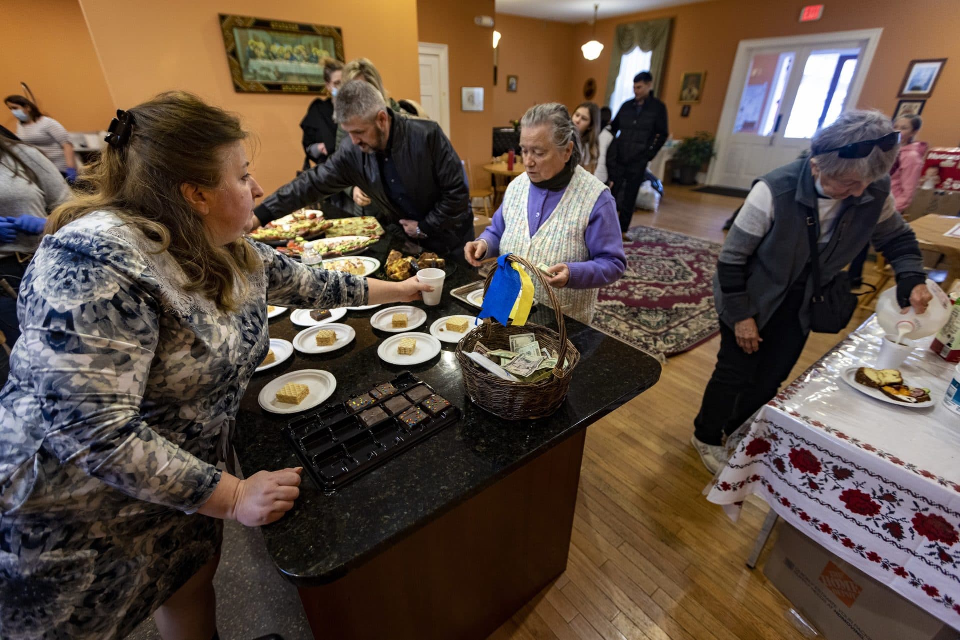 Vera Bokhenik serves traditional Ukrainian food to parishioners at Christ the King Ukrainian Catholic Church as a fundraiser to aid people in Ukraine. (Jesse Costa/WBUR)