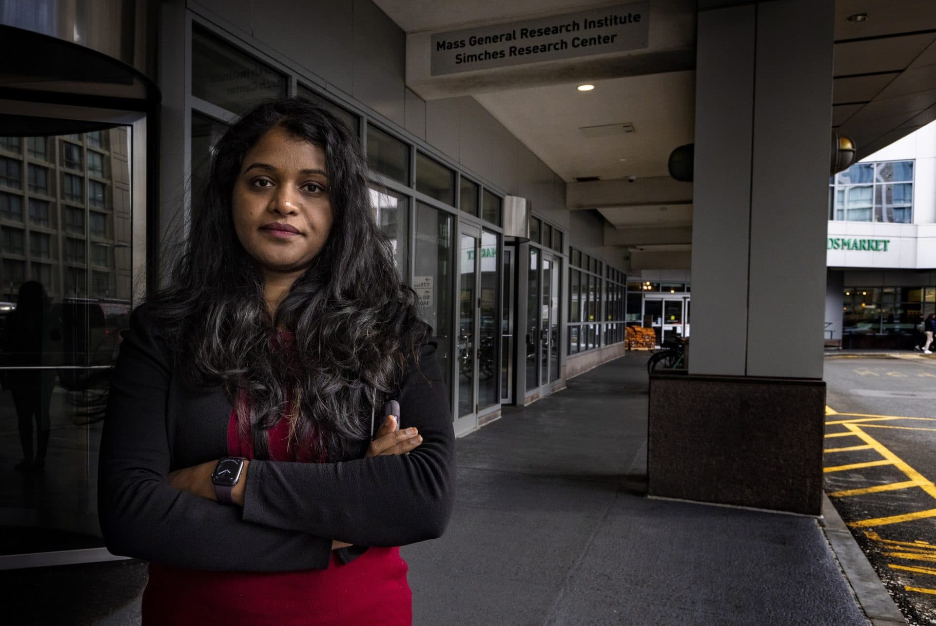 Aatira Vijay in front of the entrance of the Simches Research Center at Massachusetts General Hospital. (Jesse Costa/WBUR)