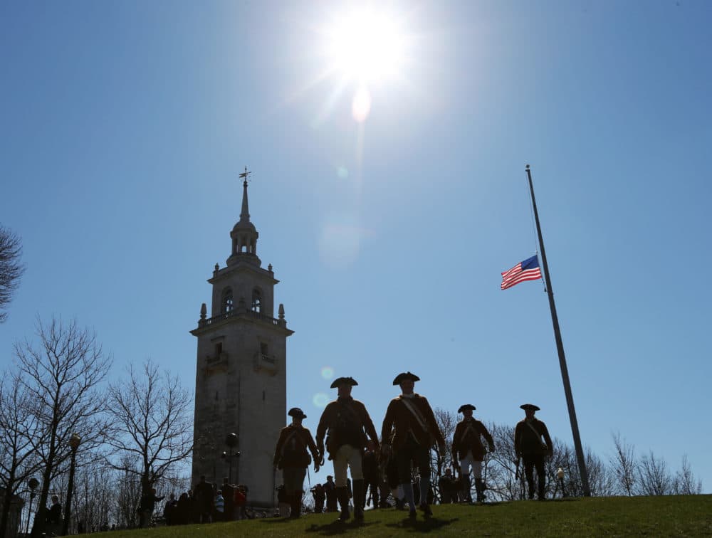 Members of the Lexington Minute Men walk down Telegraph Hill after commemorating the 240th anniversary of the fortification of Dorchester Heights and the British military evacuation of Boston on March 17, 1776. (David L. Ryan/The Boston Globe via Getty Images)