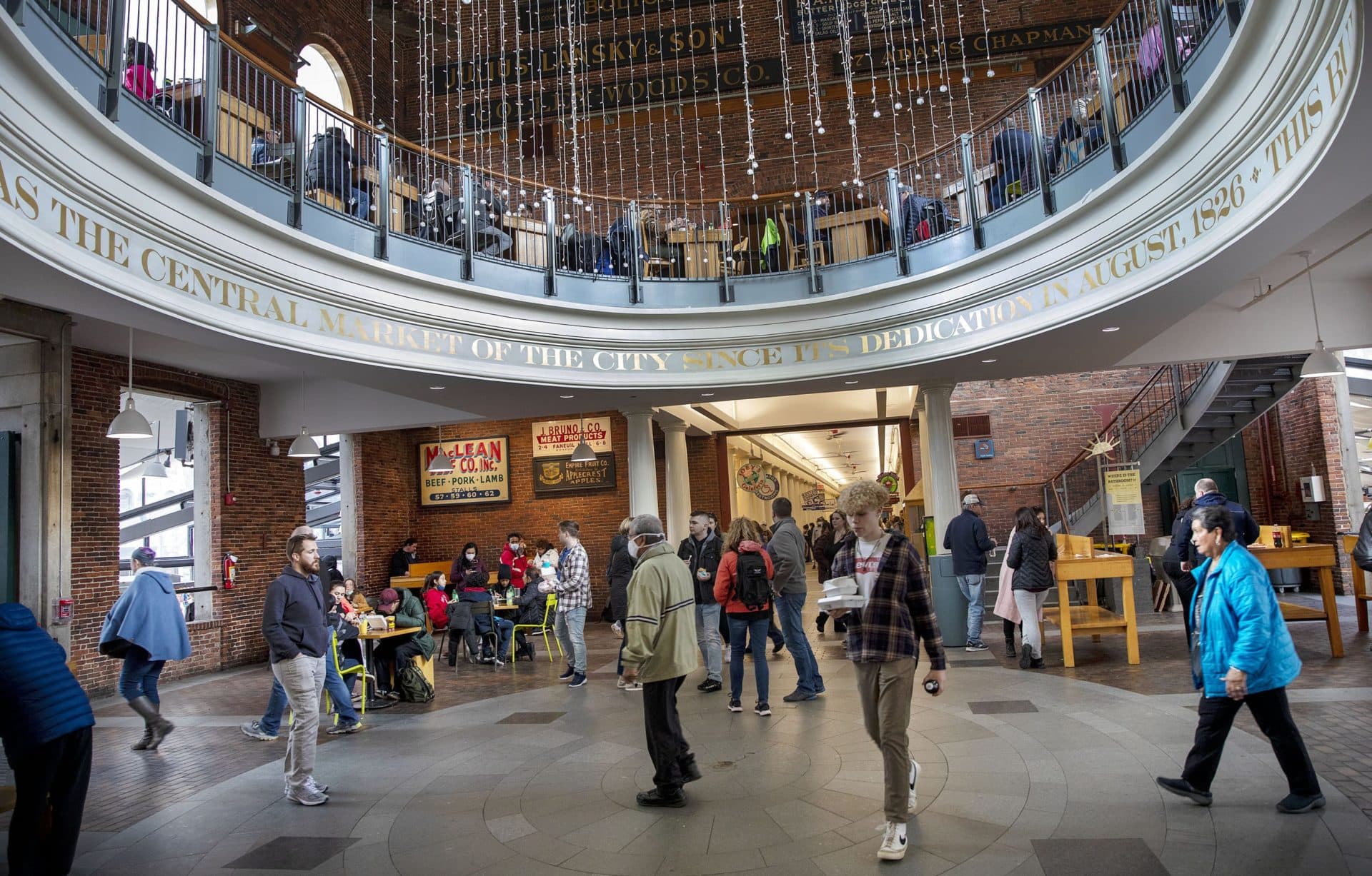 Visitors walk through the rotunda at Quincy Market, and while masks are not required, some people still choose to wear them. (Robin Lubbock/WBUR)