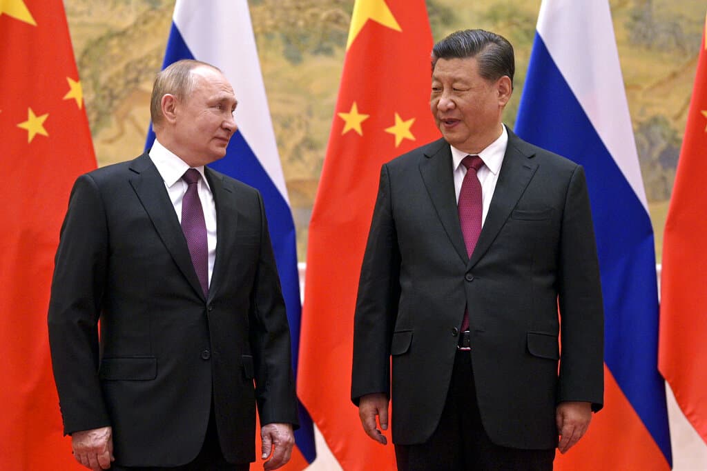 Chinese President Xi Jinping, right, and Russian President Vladimir Putin talk to each other during their meeting in Beijing, Feb. 4, 2022. China on Thursday, March 3, 2022, denounced a report that it asked Russia to delay invading Ukraine until after the Beijing Winter Olympics as "fake news" and a "very despicable" attempt to divert attention and shift blame over the conflict. (Alexei Druzhinin, Sputnik, Kremlin Pool Photo via AP, File)