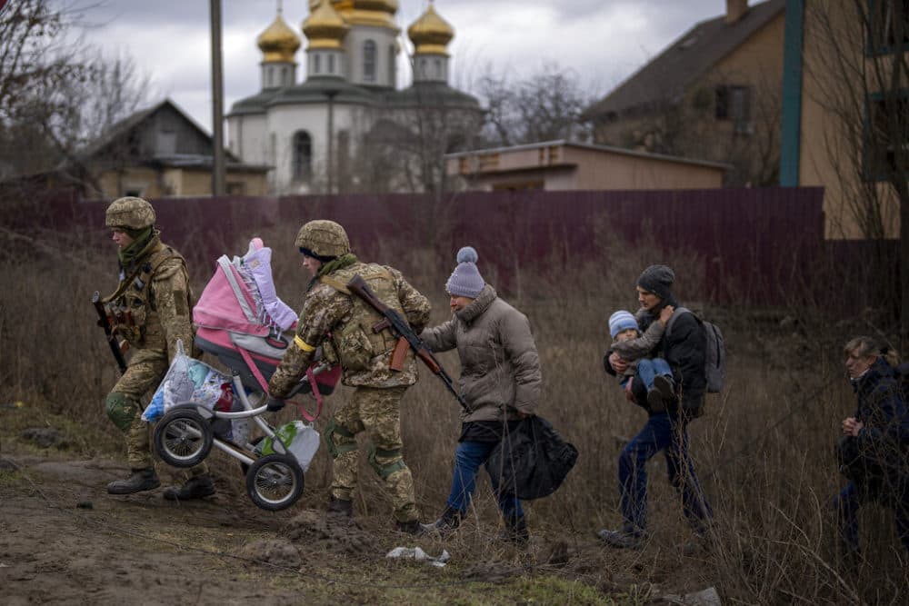 Ukrainian soldiers help a fleeing family crossing the Irpin river in the outskirts of Kyiv, Ukraine, Saturday, March 5, 2022. (Emilio Morenatti/AP)