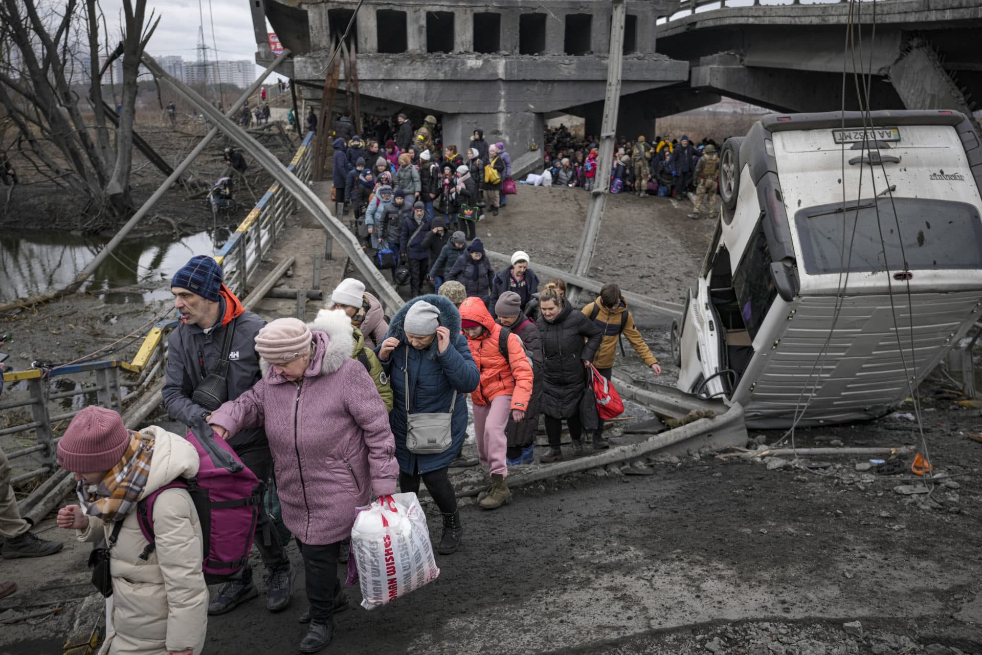People cross on an improvised path under a bridge that was destroyed by a Russian airstrike, while fleeing the town of Irpin on Saturday. (Vadim Ghirda/AP)