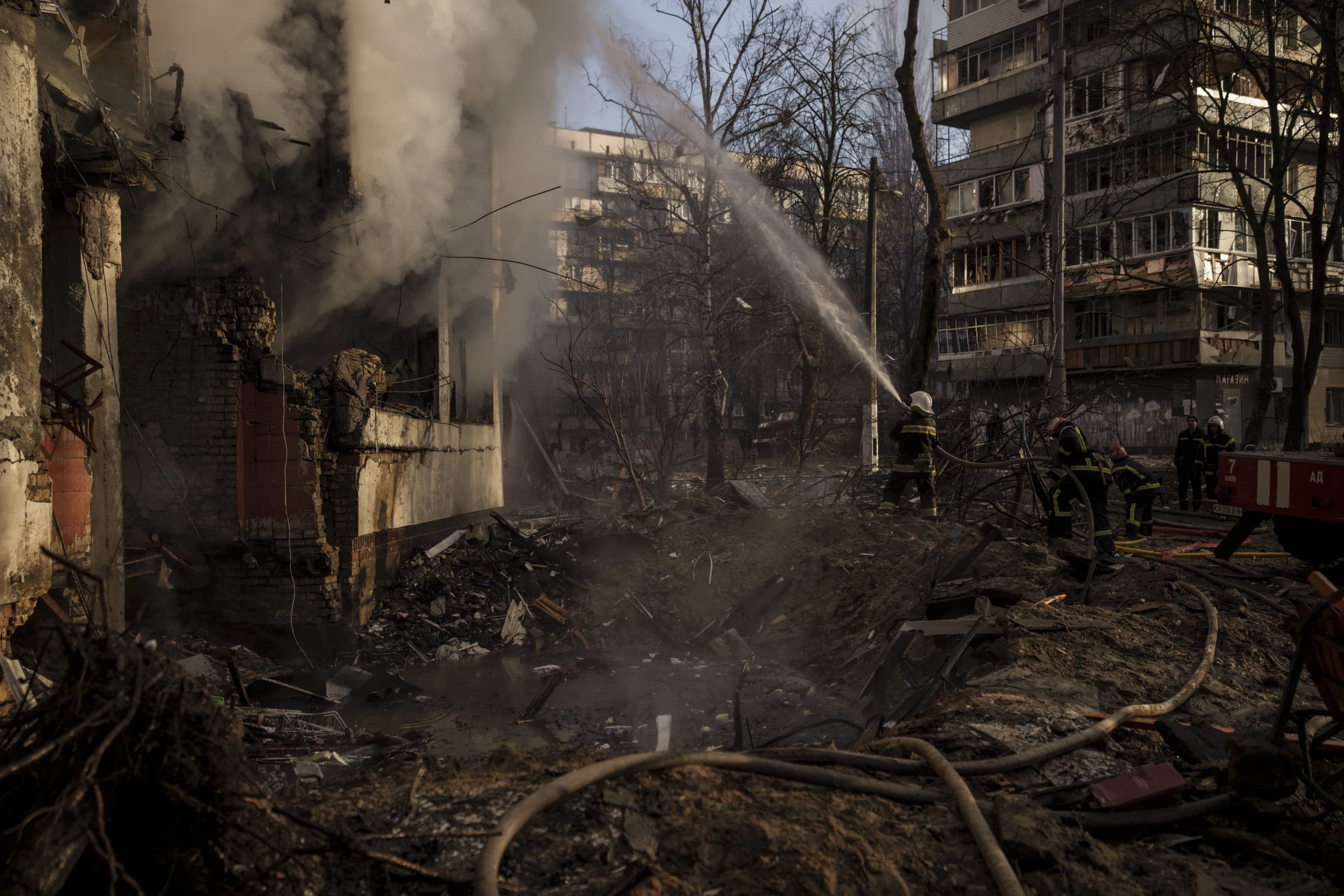 Ukrainian firefighters work in an apartment building after bombing in Kyiv, Ukraine, Tuesday, March 15, 2022. (Felipe Dana/AP)