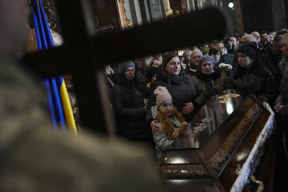 People attend a funeral ceremony for four of the Ukrainian military servicemen, who were killed during an airstrike in a military base in Yarokiv, in a church in Lviv, Ukraine, Tuesday, March 15, 2022.(Bernat Armangue/Ap)