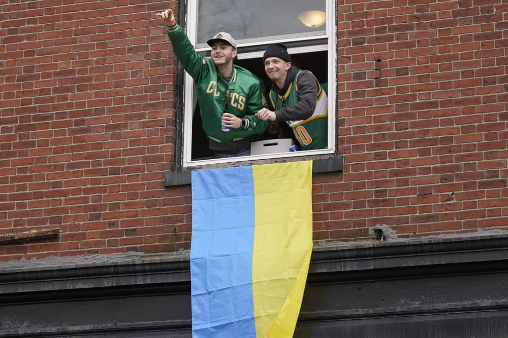 Spectators watch the St. Patrick's Day parade from a window with a Ukrainian flag. (Steven Senne/AP)