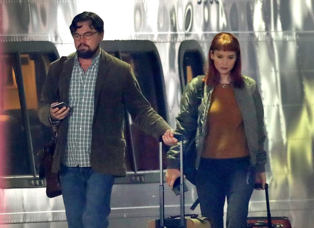 Actors Leonardo DiCaprio and Jennifer Lawrence walk along the train platform next to an Acela train at South Station during on location filming of "Don't Look Up" at South Station in Boston on Dec. 1, 2020. (David L. Ryan/The Boston Globe via Getty Images)
