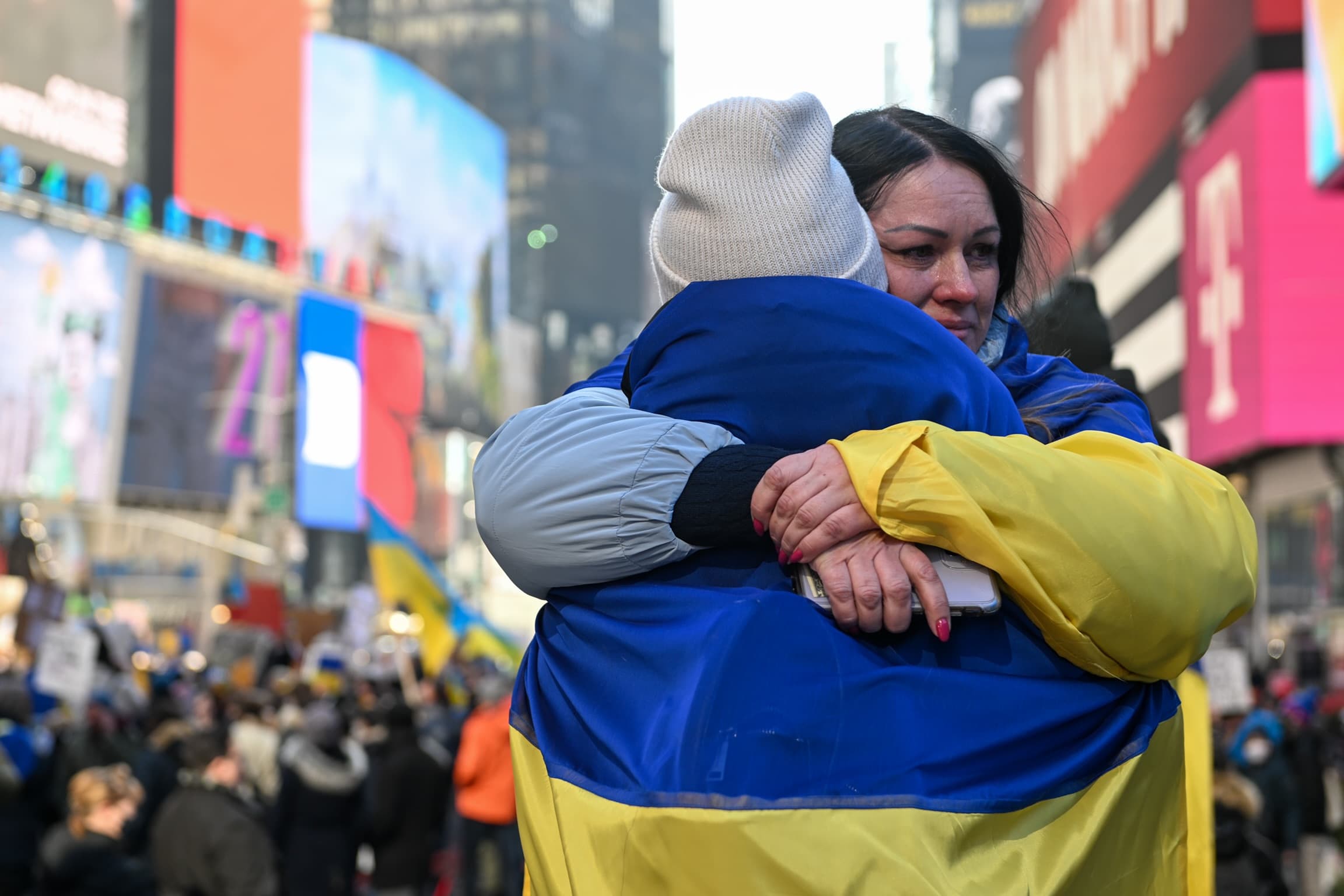 Two people draped in Ukrainian flags embrace at a "Stand With Ukraine" rally in Times Square on Feb. 26, 2022 in New York City. (Alexi Rosenfeld/Getty Images)