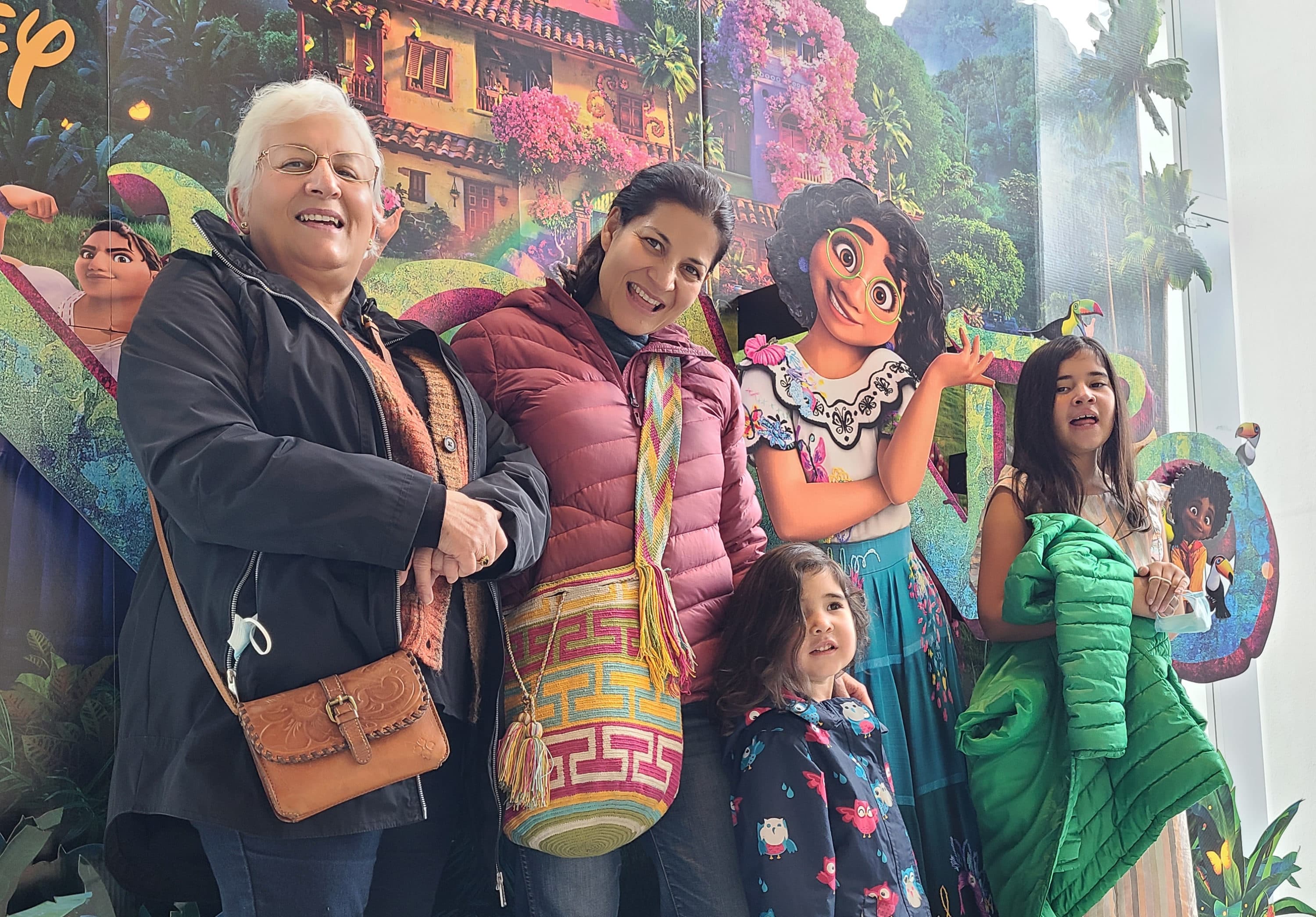 The author and her family pose in front of the "Encanto" movie poster. (Courtesy of Lorena Hernández Leonard)