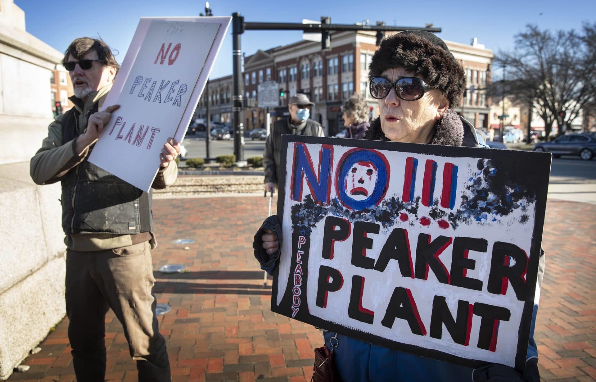 Mary Klug holds up a sign saying &quot;No Peaker Plant&quot; at a rally to stop the construction of a new gas peaker power plant in Peabody. (Robin Lubbock/WBUR)