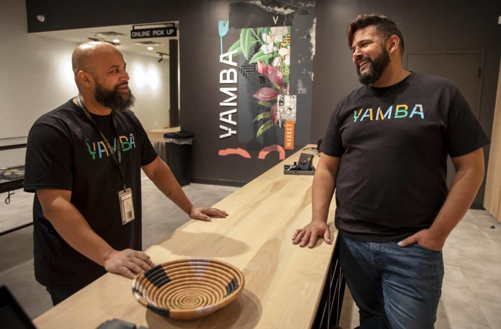 Yamba Market CEO Sieh Samura and Director of Retail Operations Ronnie Strunk talk at the sales counter, as opening day for the store fast approaches. (Robin Lubbock/WBUR)