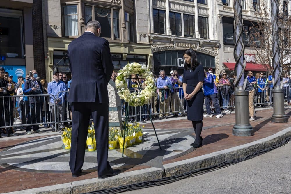 Baker and Wu stand for a moment of silence at the Marathon Bombing Memorial at 671 Boylston St. (Jesse Costa/WBUR)