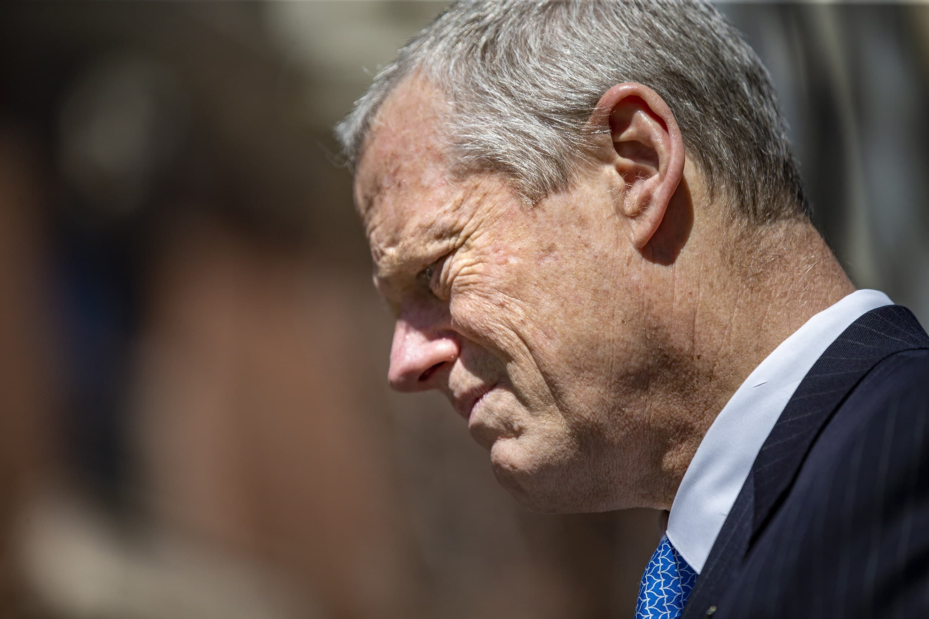 Baker stands during a moment of silence at the site of the second bomb explosion. (Jesse Costa/WBUR)