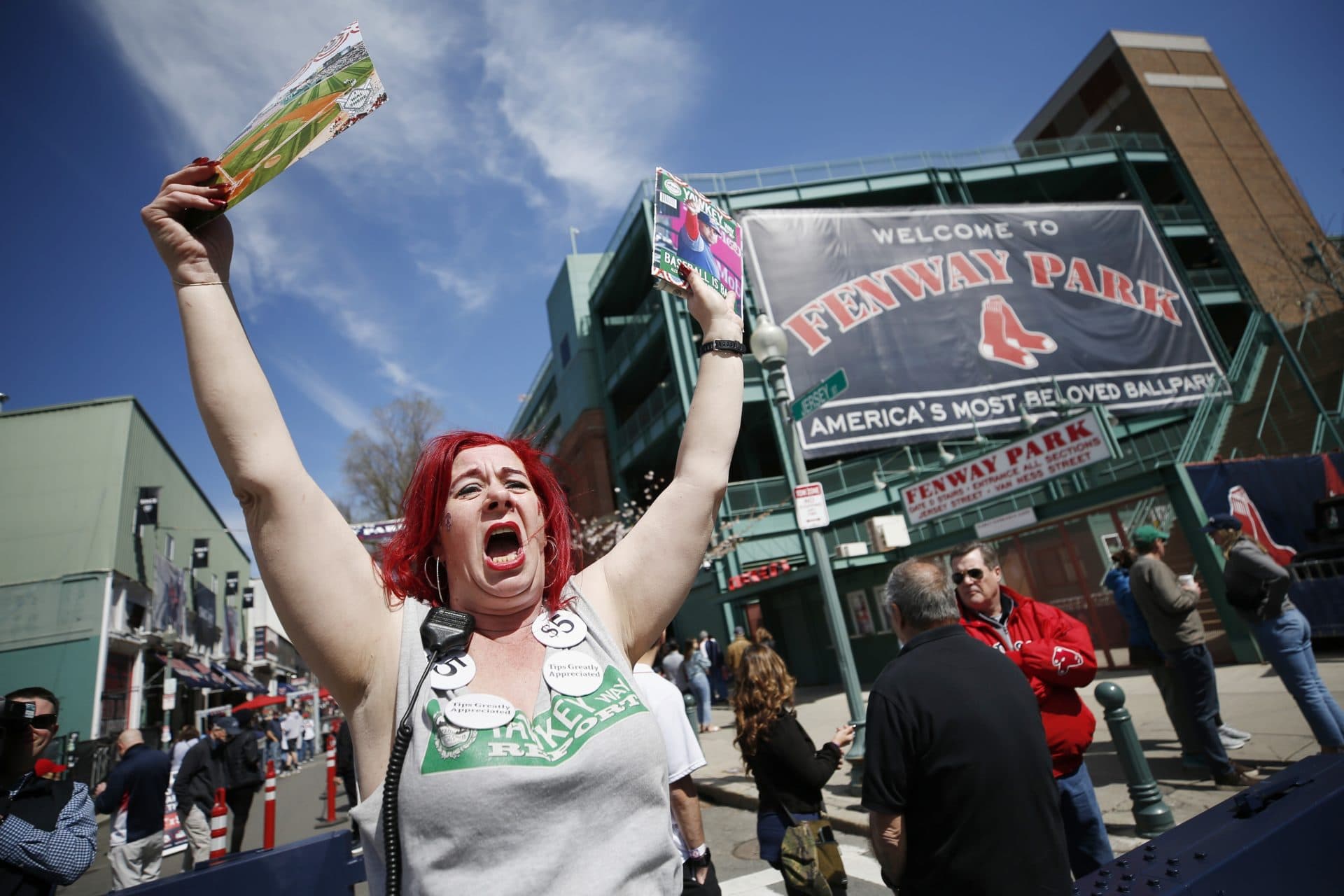 A woman sells programs outside Fenway Park opening day Friday. (Michael Dwyer/AP)
