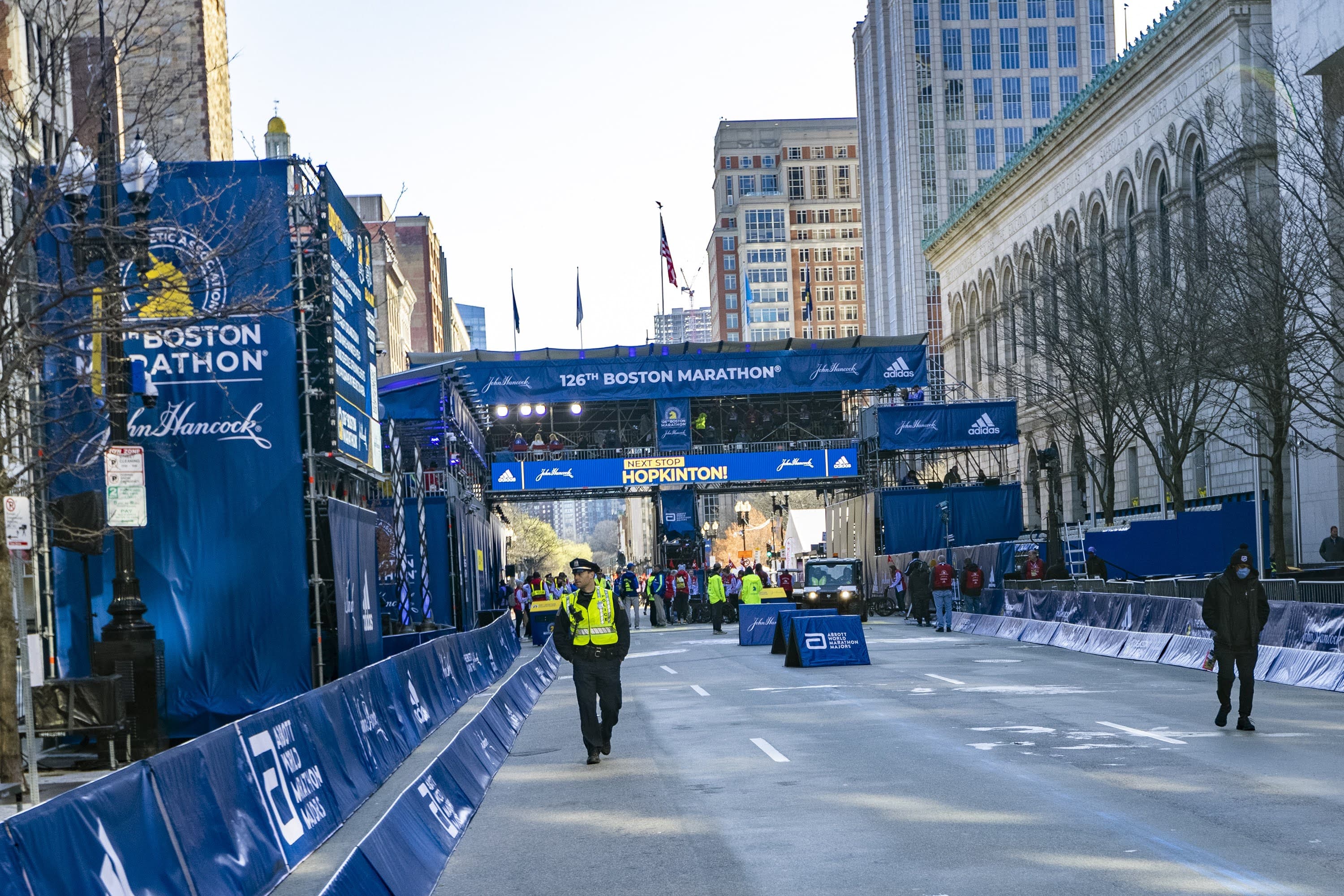 An officer walks along Boylston Street hours before thousands of Boston Marathon runners descend upon the area. (Jesse Costa/WBUR)
