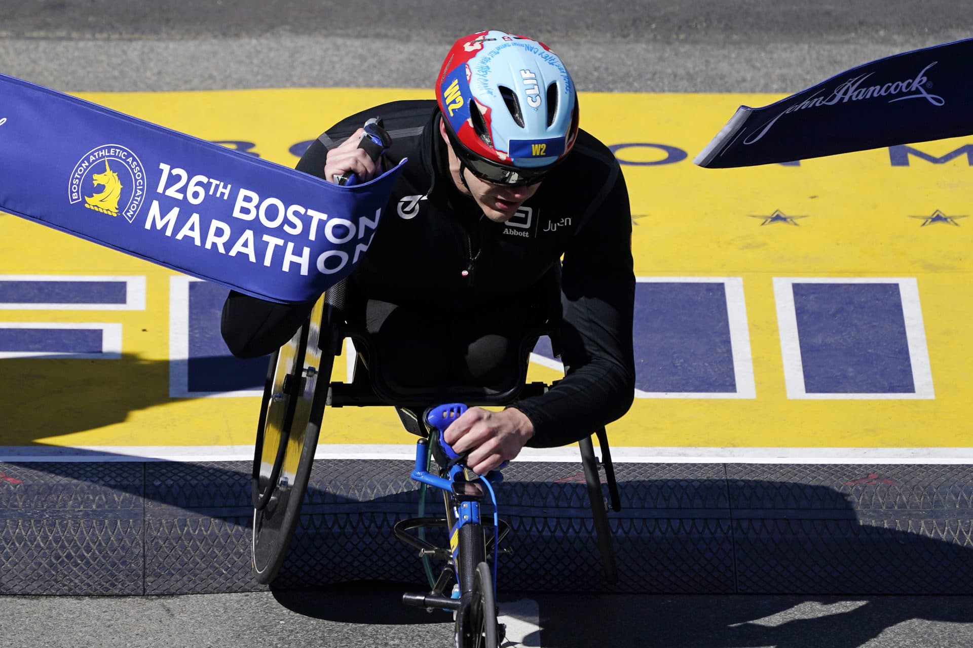 Daniel Romanchuk, of the United States, breaks the tape to win the men's wheelchair division of the Boston Marathon, Monday, April 18, 2022, in Boston. (Charles Krupa/AP)