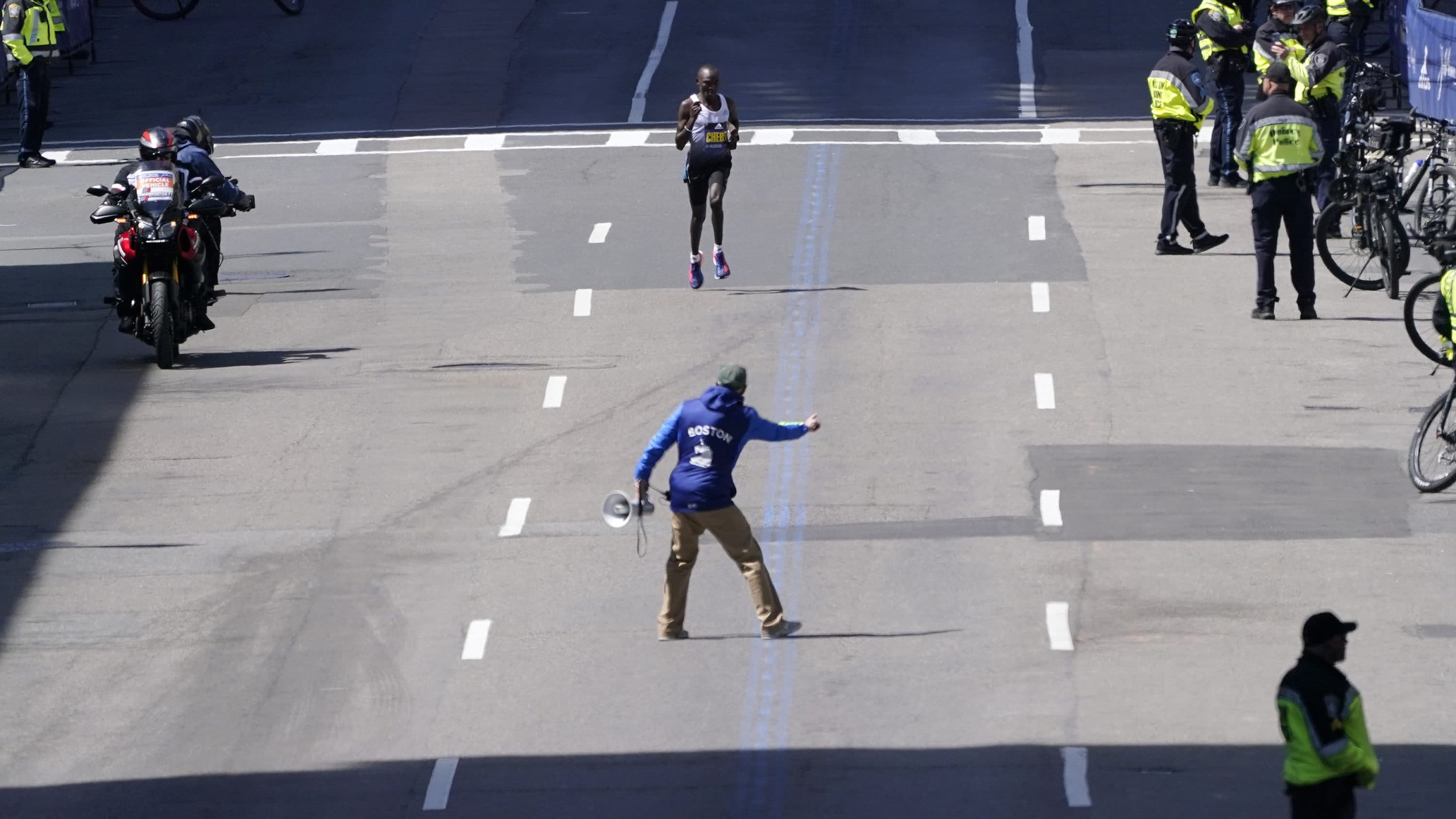 Evans Chebet, of Kenya, is guided towards the finish line to win the 2022 Boston Marathon. (Charles Krupa/AP)