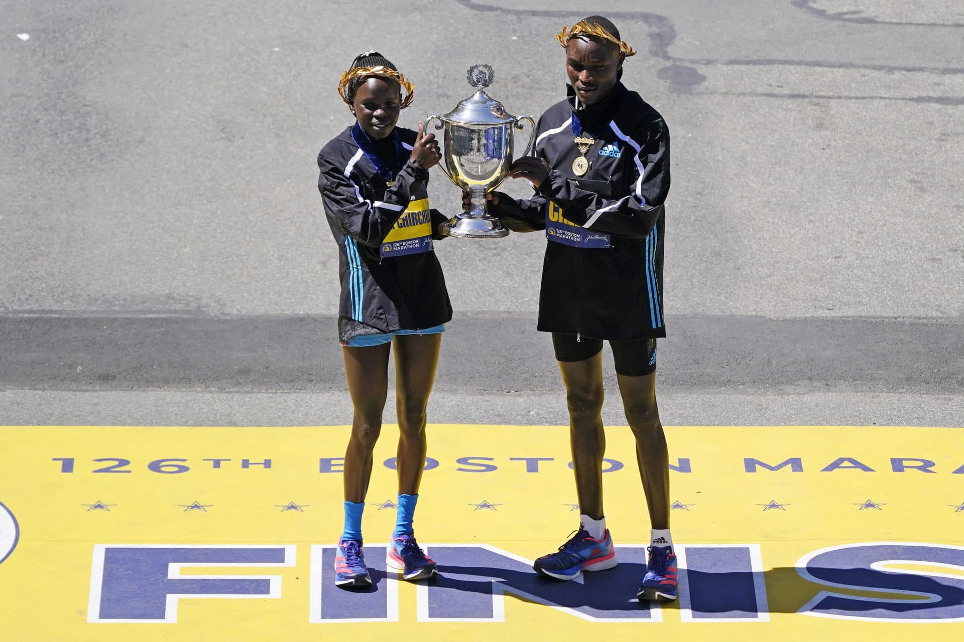 The 2022 Boston Marathon women's division winner Peres Jepchirchir, of Kenya, left, and men's winner Evans Chebet, of Kenya, pose at the finish line. (Charles Krupa/AP)