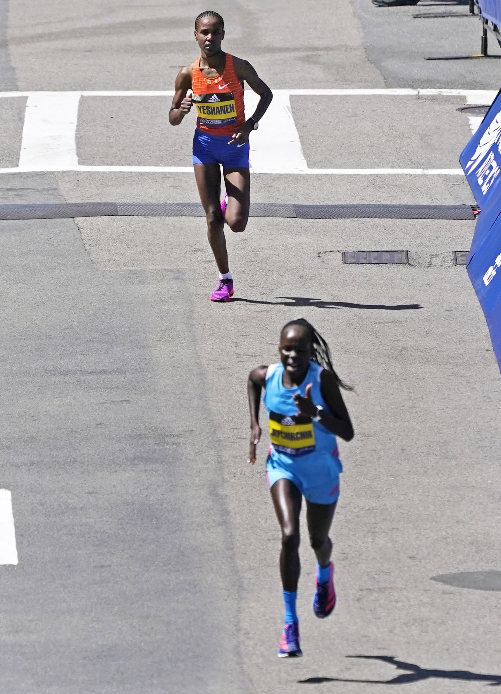 Ababel Yeshaneh, of Ethiopia, top, tries to keep pace but is outrun by Peres Jepchirchir, of Kenya, bottom, as they approach the finish line of the Boston Marathon, Monday, April 18, 2022, in Boston. Jepchirchir won the women's division, Yeshaneh ran second. (AP Photo/Charles Krupa)