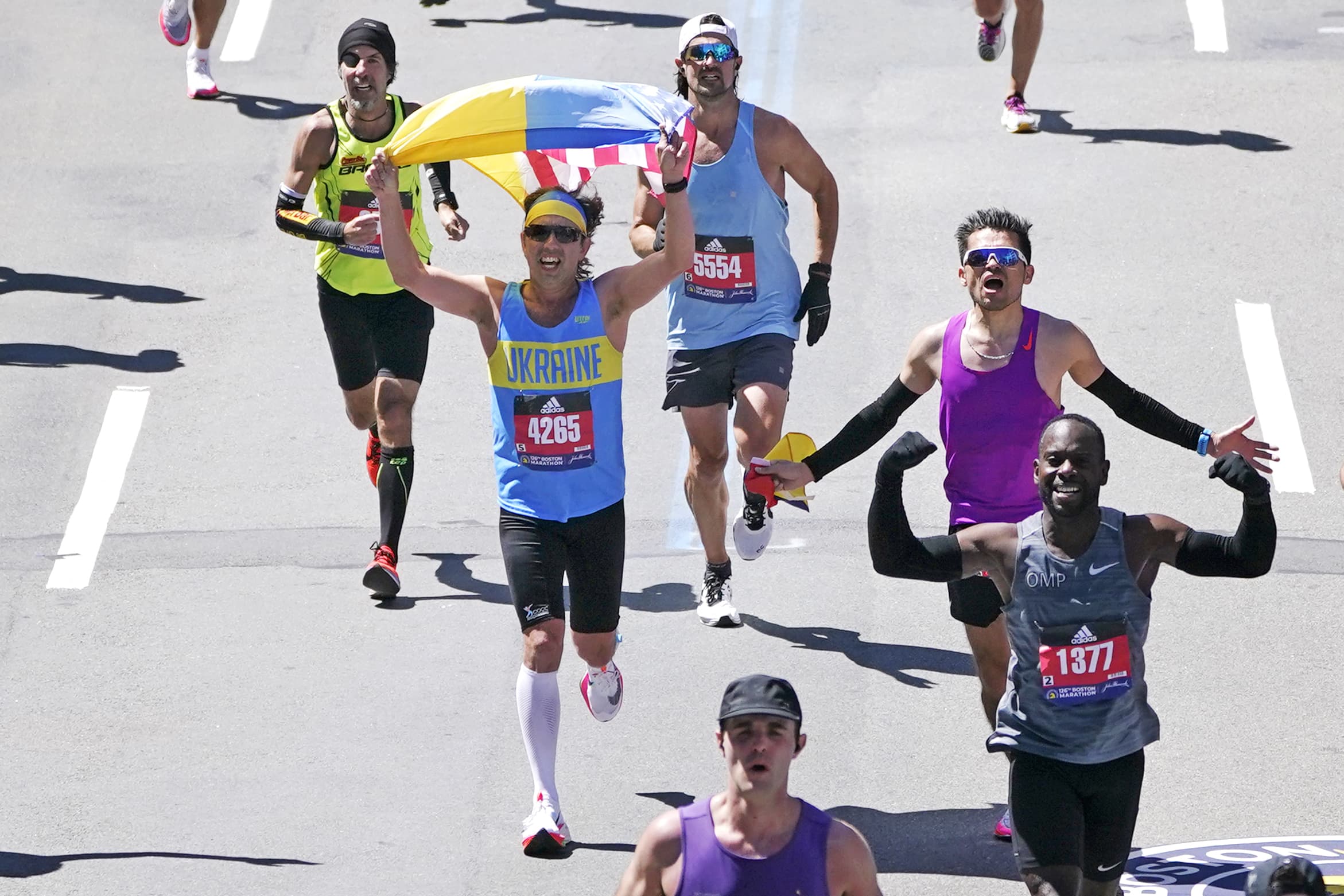 While dressed in a Ukraine shirt, a runner holds a Ukraine and American flag while approaching the finish line of the 2022 Boston Marathon. (Charles Krupa/AP)