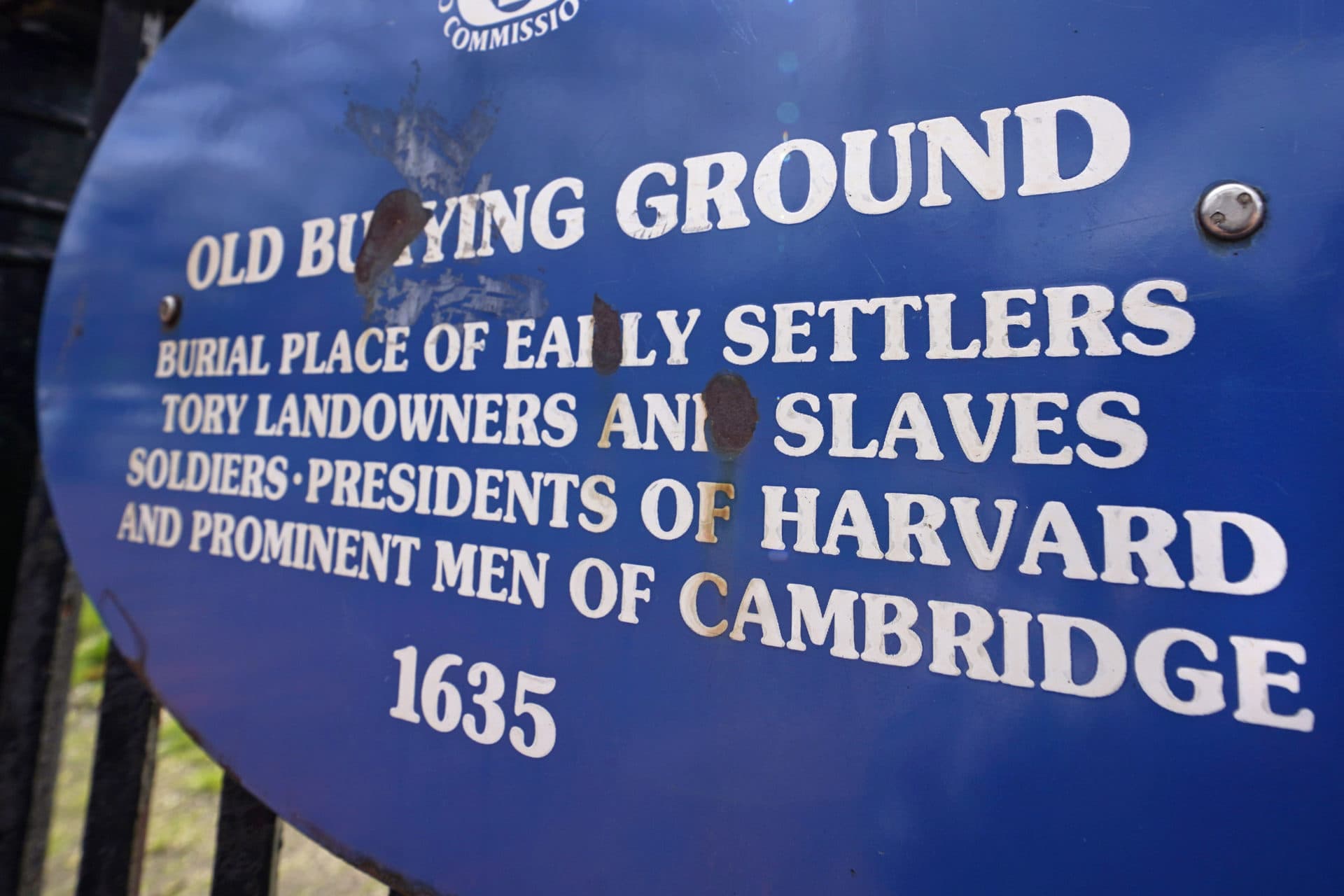 A sign on a gate leading to the Old Burying Ground lists the resting place of Harvard community leaders, and some of the people they enslaved, just outside Harvard Yard, April 27, 2022, in Cambridge, Mass.(Charles Krupa/AP)