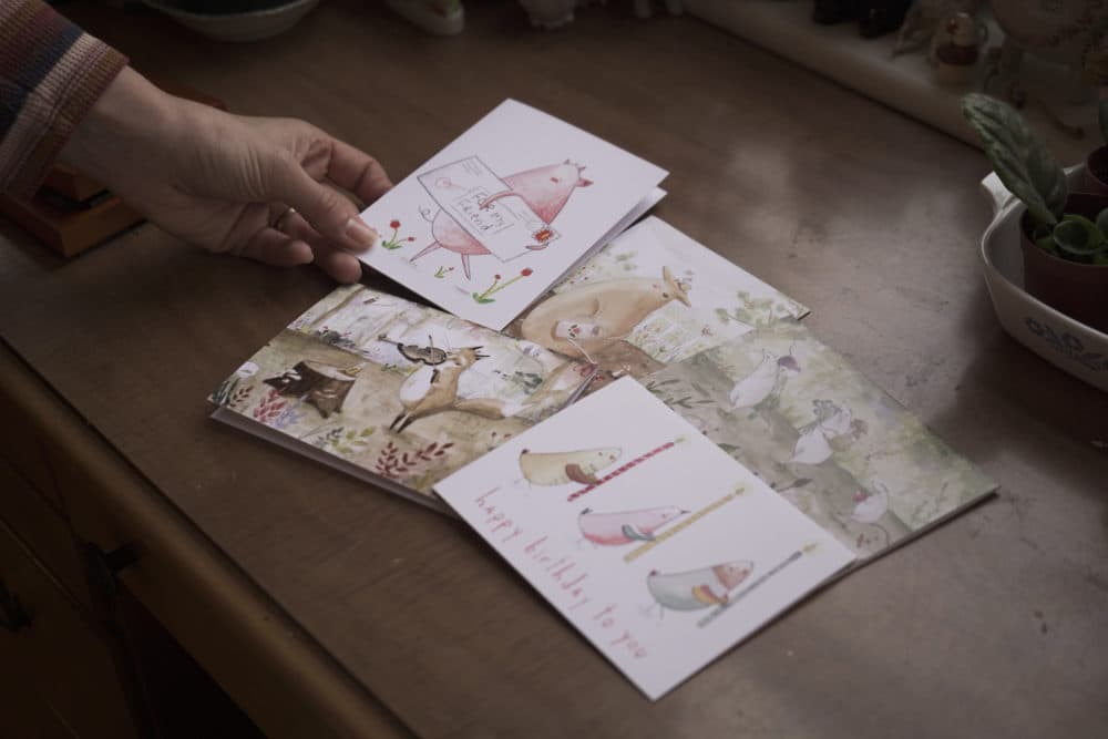 Illustrator Lindsay Blevins uses watercolors to create one-of-a-kind cards that she sells on Etsy. (Arielle Gray/WBUR)