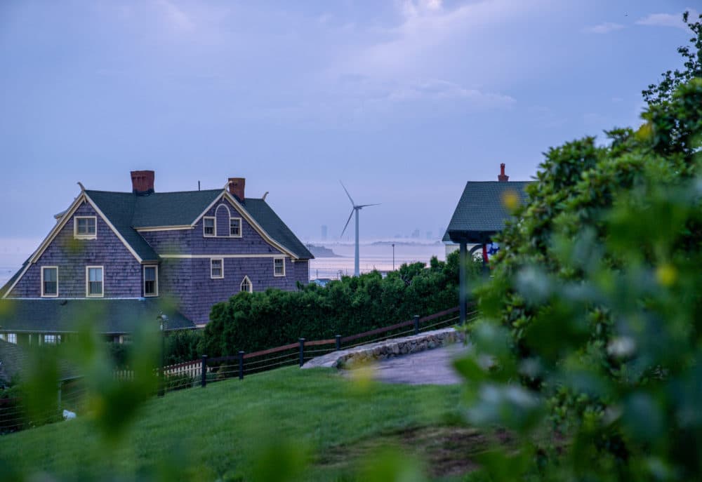 A wind turbine is visible between two residences July 14, 2021 in Hull, Massachusetts. (Robert Nickelsberg/Getty Images)