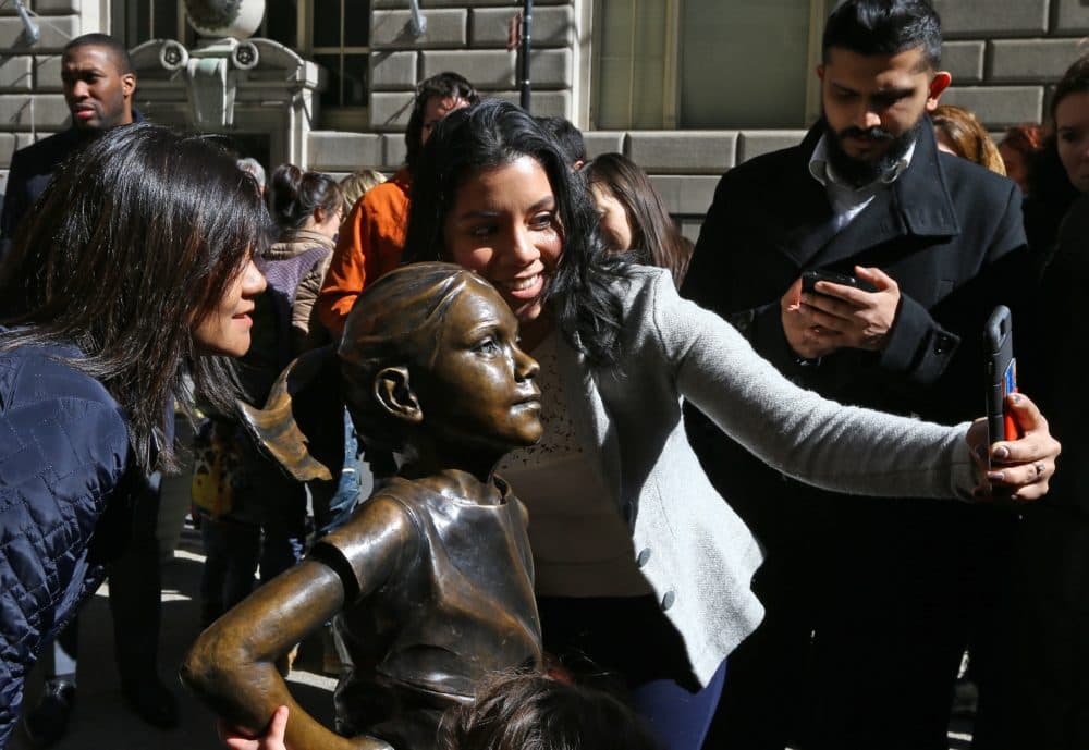 People take photos of the 'The Fearless Girl' statue as it stands across from the Wall Street's famous Charging Bull to draw attention to the gender equality and lack of female managers on the International Women's Day , in New York, United States on March 08, 2017. (Volkan Furuncu/Anadolu Agency/Getty Images)