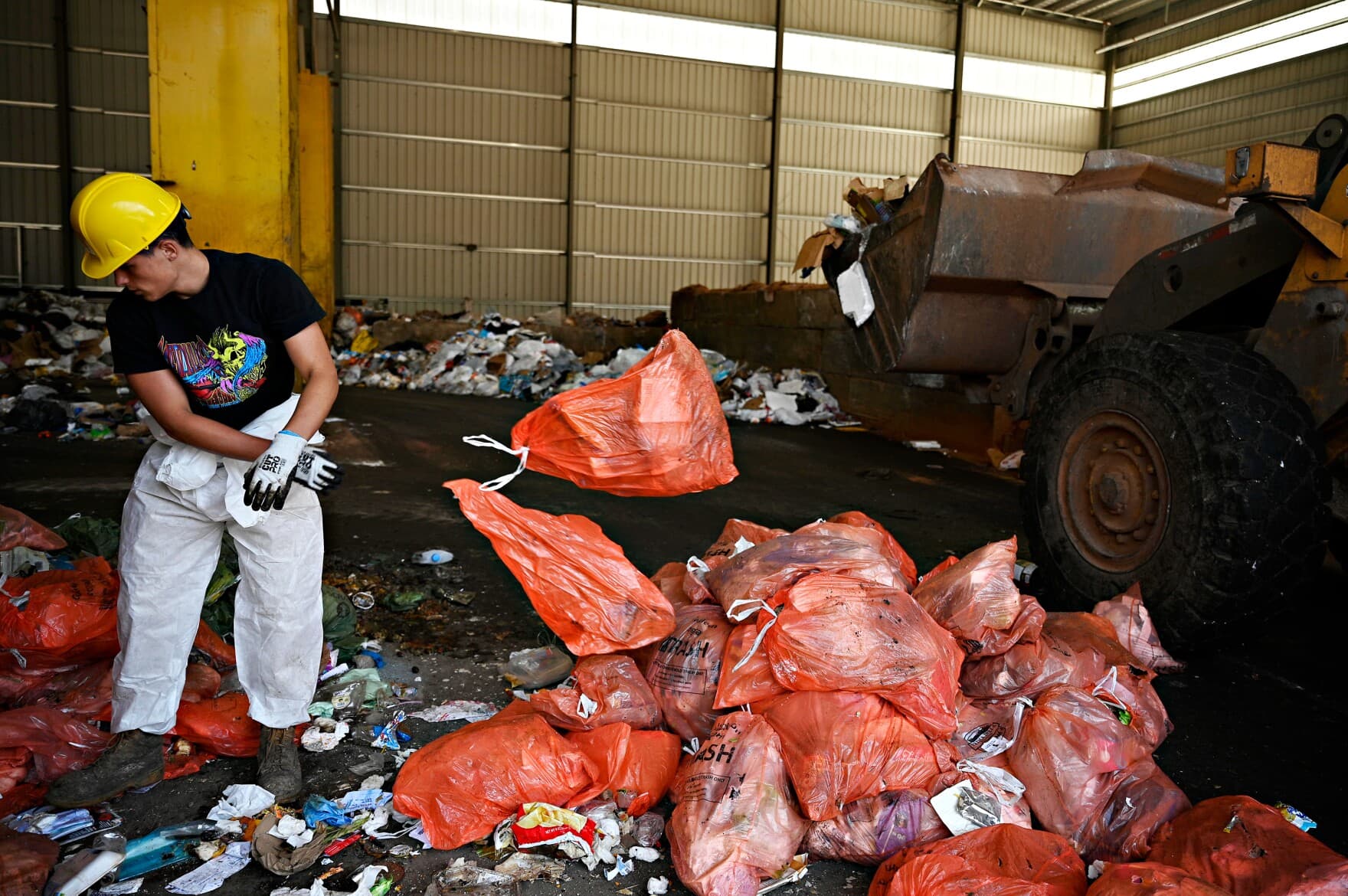 Cody Talento, who works for the city of Meriden, Connecticut, separates bags of trash from bags of food scraps at HQ Dumpsters & Recycling in Southington. The food waste will be taken to an anaerobic digester to be turned into electrical energy and compost. About 1,000 households in Meriden are participating in a municipal food recycling pilot program.
