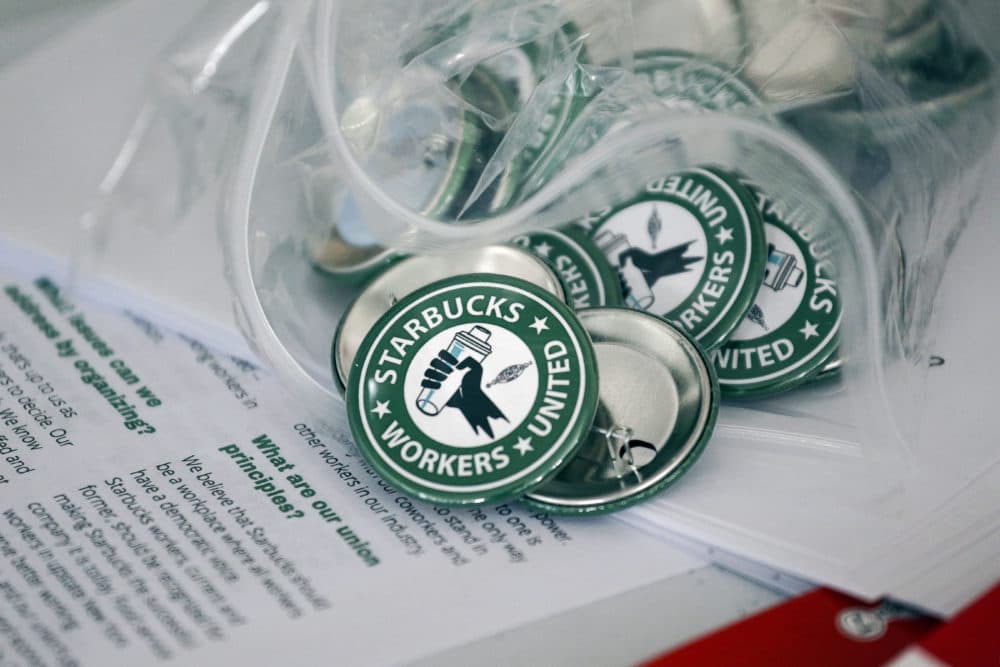 Pro-union pins sit on a table during a watch party for Starbucks' employees union election last year in Buffalo, N.Y. Workers at two Starbucks locations in eastern Massachusetts became the first in the state to vote to unionize Monday. (Joshua Bessex/AP)