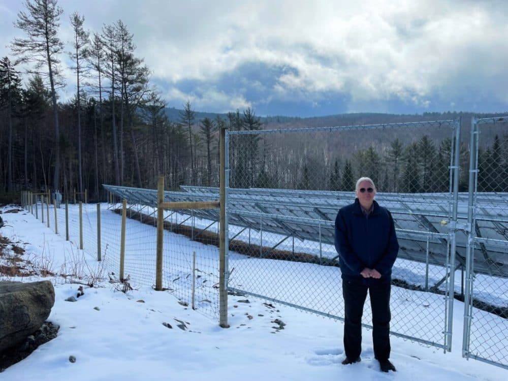 David Van Houten stands next to the Profile High School's solar array in Bethlehem. He's been working on local energy issues in his community for 15 years but said he wishes the state were playing a stronger role supporting these efforts. (Mara Hoplamazian/NHPR)