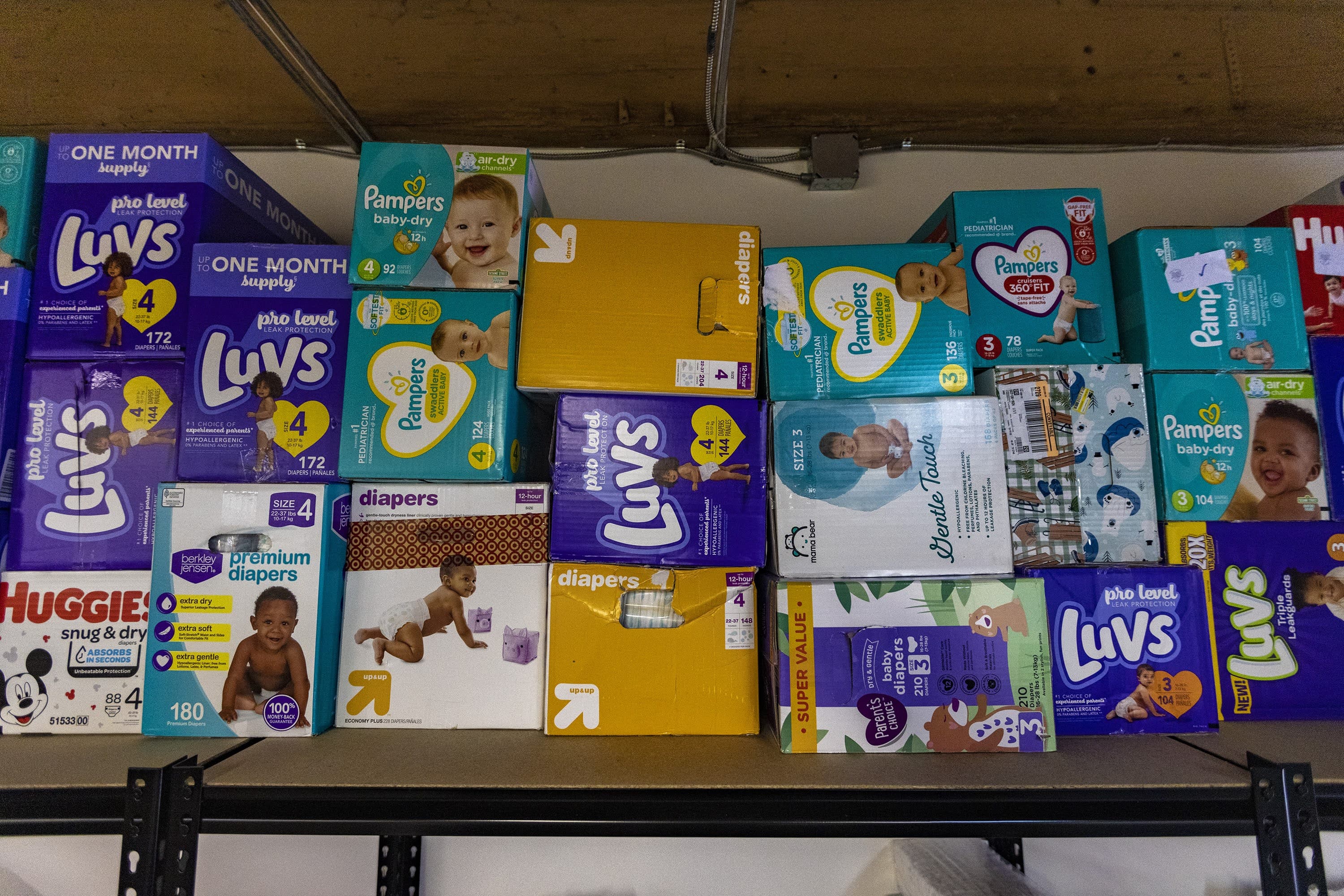 Boxes of diapers of all different sizes sit on a shelf for distribution at the diaper bank. (Jesse Costa/WBUR)