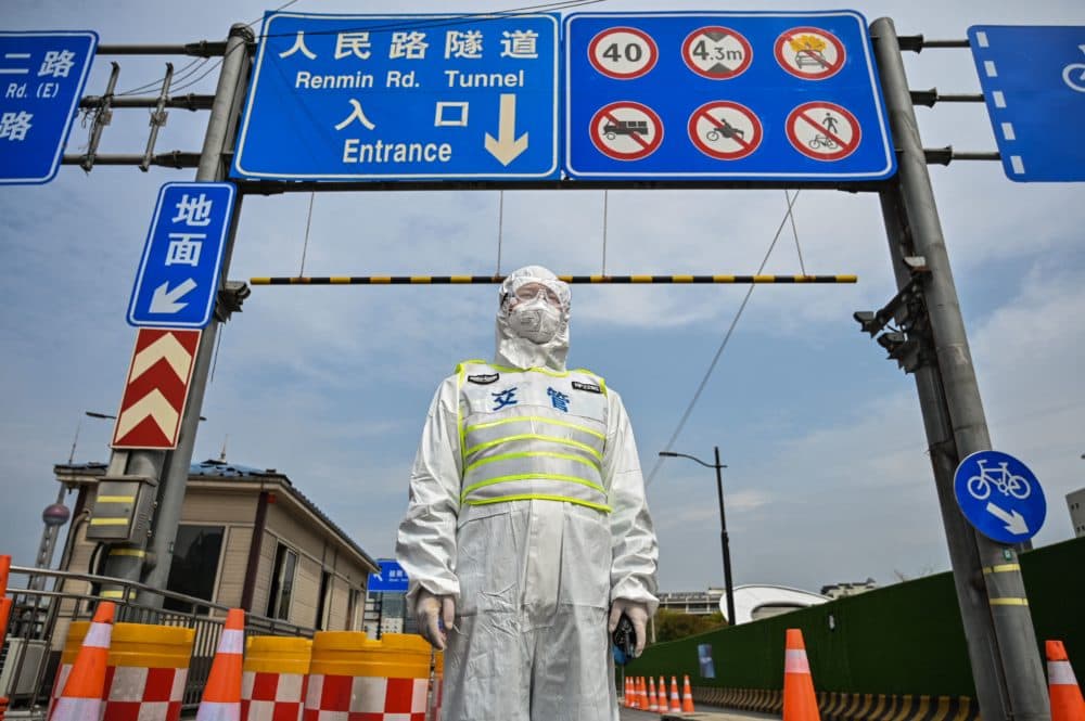 A transit officer, wearing a protective gear, controls access to a tunnel in the direction of Pudong district in lockdown as a measure against the Covid-19 coronavirus, in Shanghai on March 28, 2022. (HECTOR RETAMAL/AFP via Getty Images)