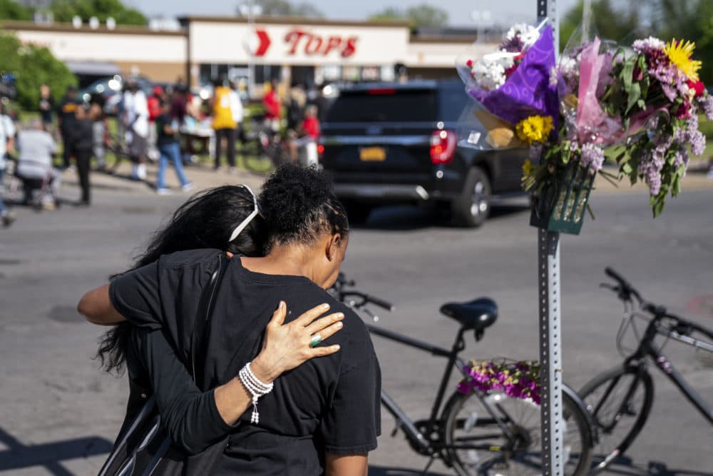 Jeanne LeGall, of Buffalo, hugs Claudia Carballada, of Buffalo, as she gets emotional, as she pays her respects at an makeshift memorial as people gather at the scene of a mass shooting at Tops Friendly Market at Jefferson Avenue and Riley Street on Sunday, May 15, 2022 in Buffalo, NY. (Kent Nishimura / Los Angeles Times via Getty Images)