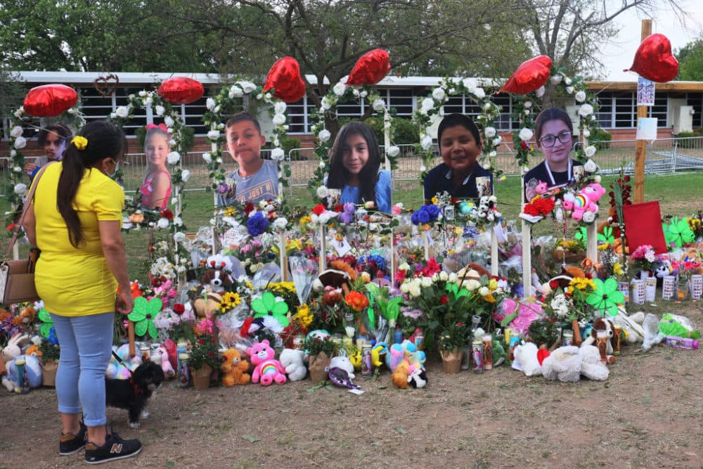 A woman looks down at a memorial for the 19 children and two adults killed on May 24th during a mass shooting at Robb Elementary School on May 30, 2022 in Uvalde, Texas. (Michael M. Santiago/Getty Images)